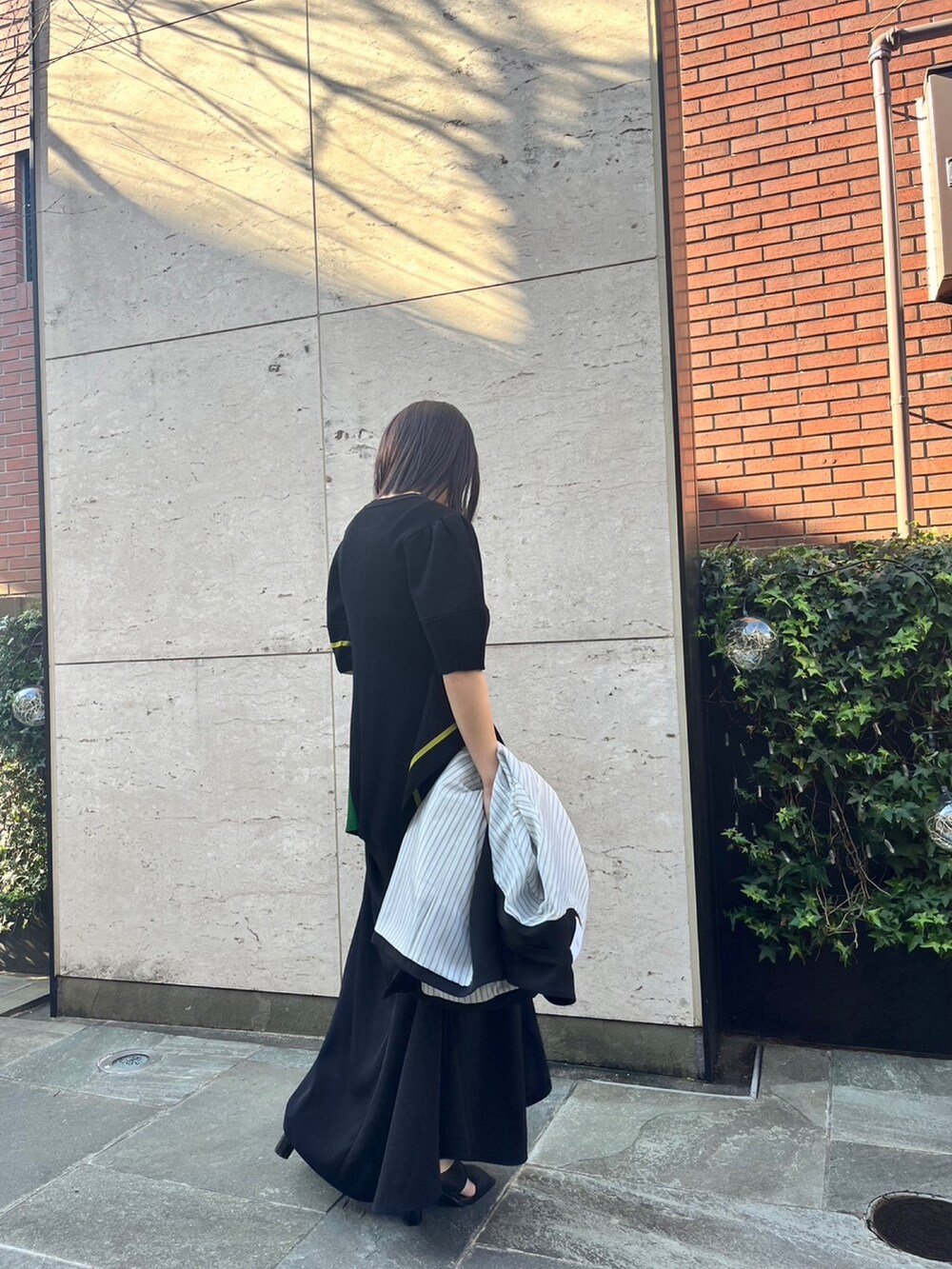 ブラック系のスカート、ブラック系のパンプス、ブラック系のテーラードジャケットを着用したレディースの冬コーディネートの5枚目の写真