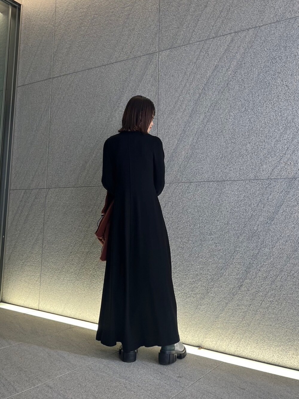 ブラック系のワンピース、その他のブーツ、シルバー系のピアス（両耳用）を着用したレディースの冬コーディネートの3枚目の写真