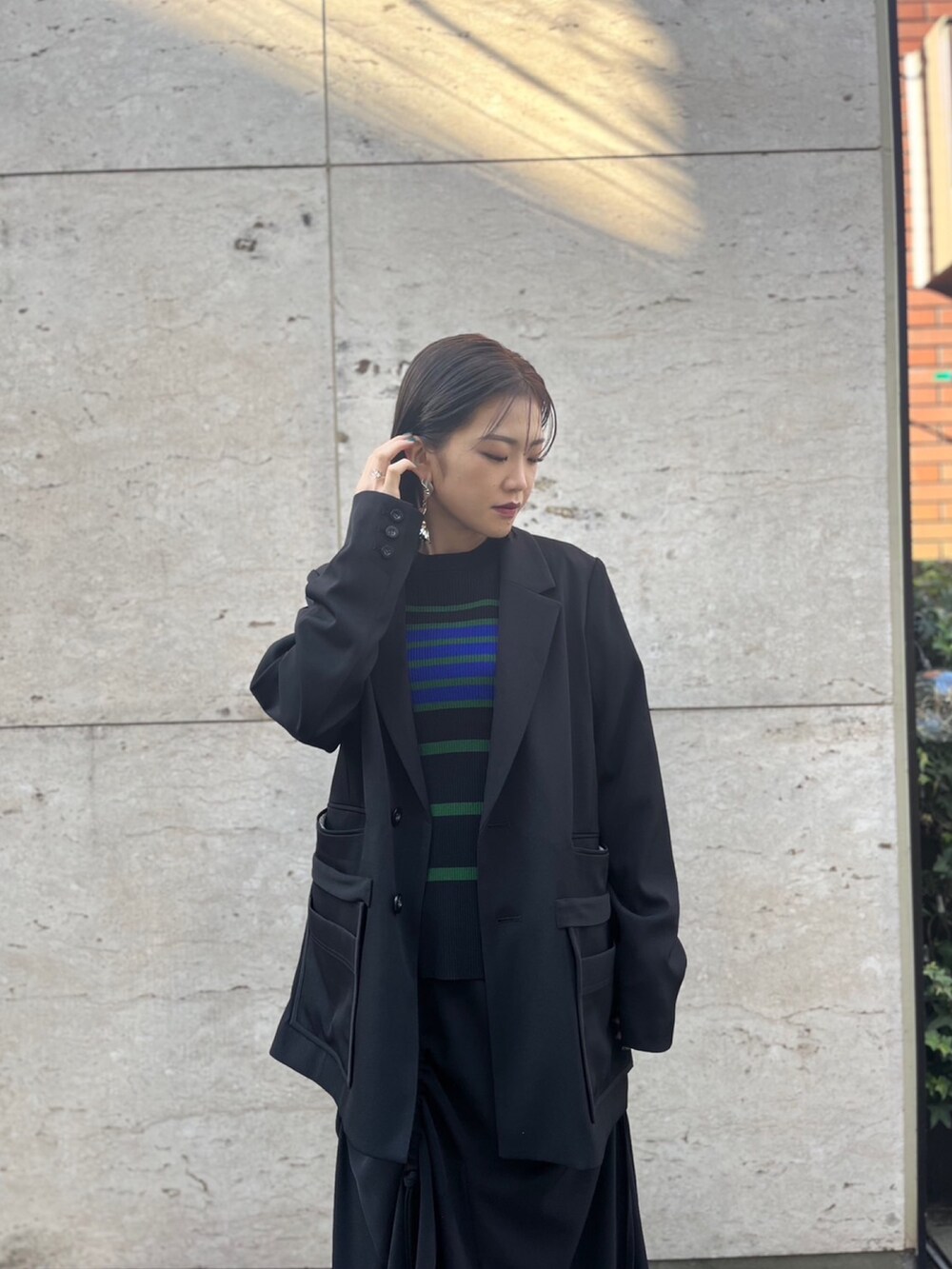 ブラック系のスカート、ブラック系のパンプス、ブラック系のテーラードジャケットを着用したレディースの冬コーディネートの6枚目の写真