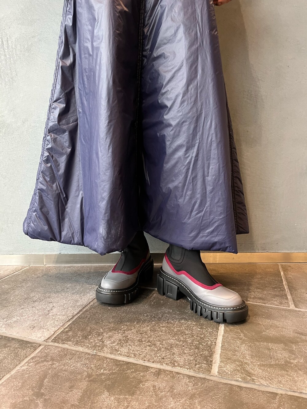 グレー系のブーツ、ブルー系のワンピース、シルバー系のネックレスを着用したレディースの秋コーディネートの9枚目の写真