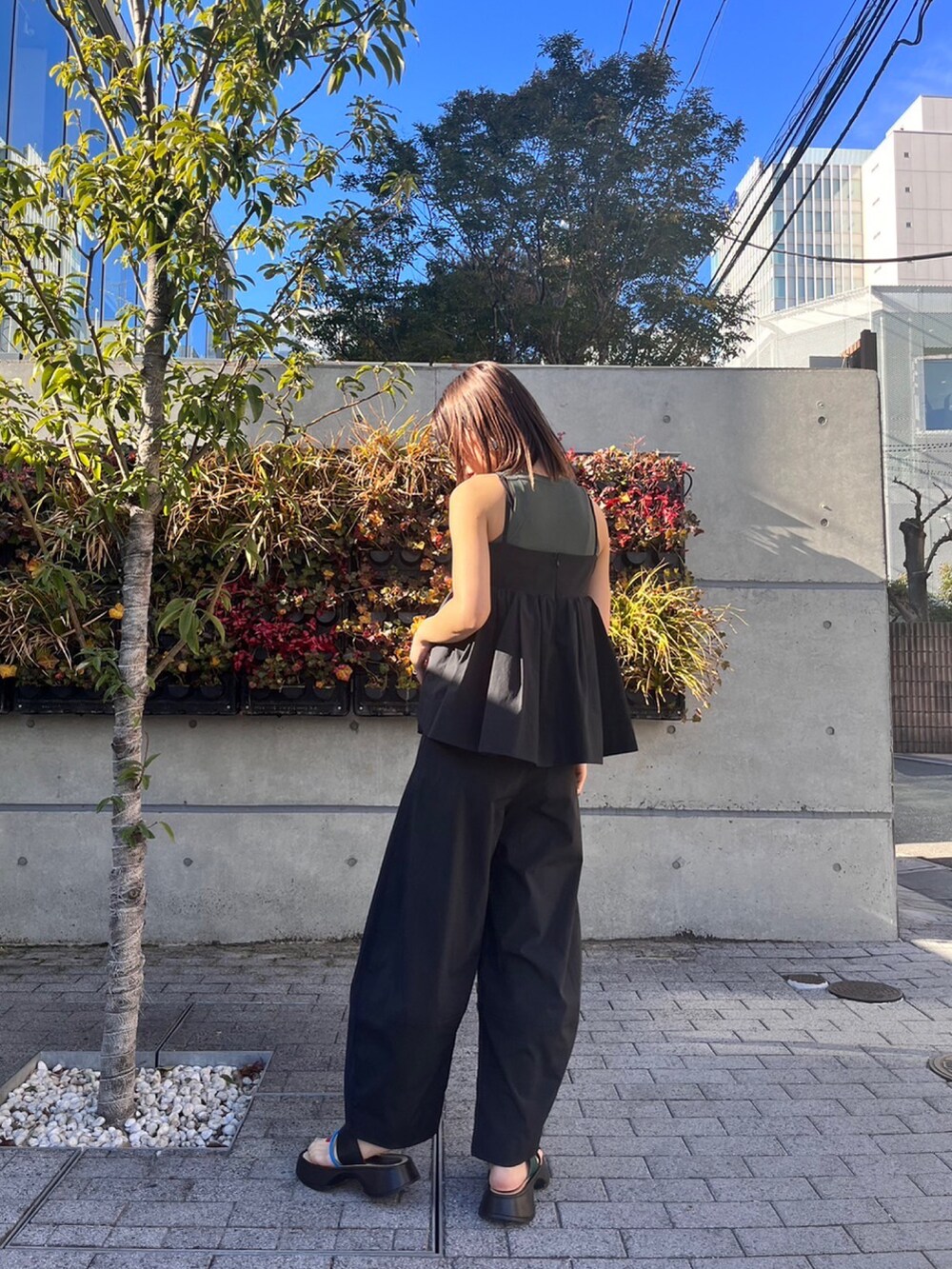 ブラック系のキャミソール、ブラック系のその他パンツ、その他のサンダルを着用したレディースの冬コーディネートの2枚目の写真