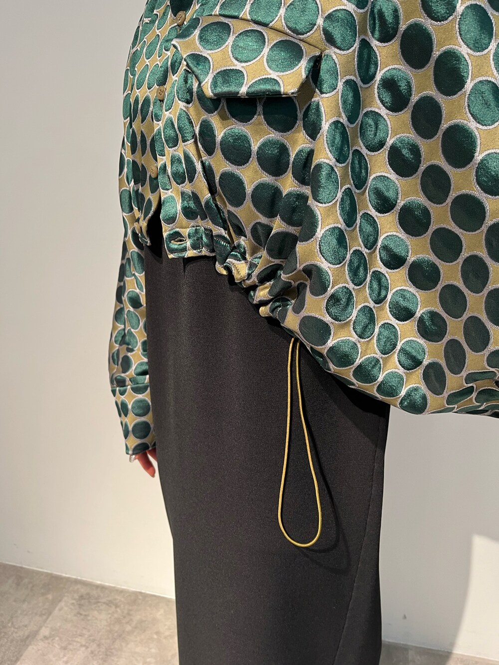 グリーン系のブルゾン、ブラック系のワンピース、グレー系のブーツを着用したレディースの秋コーディネートの4枚目の写真