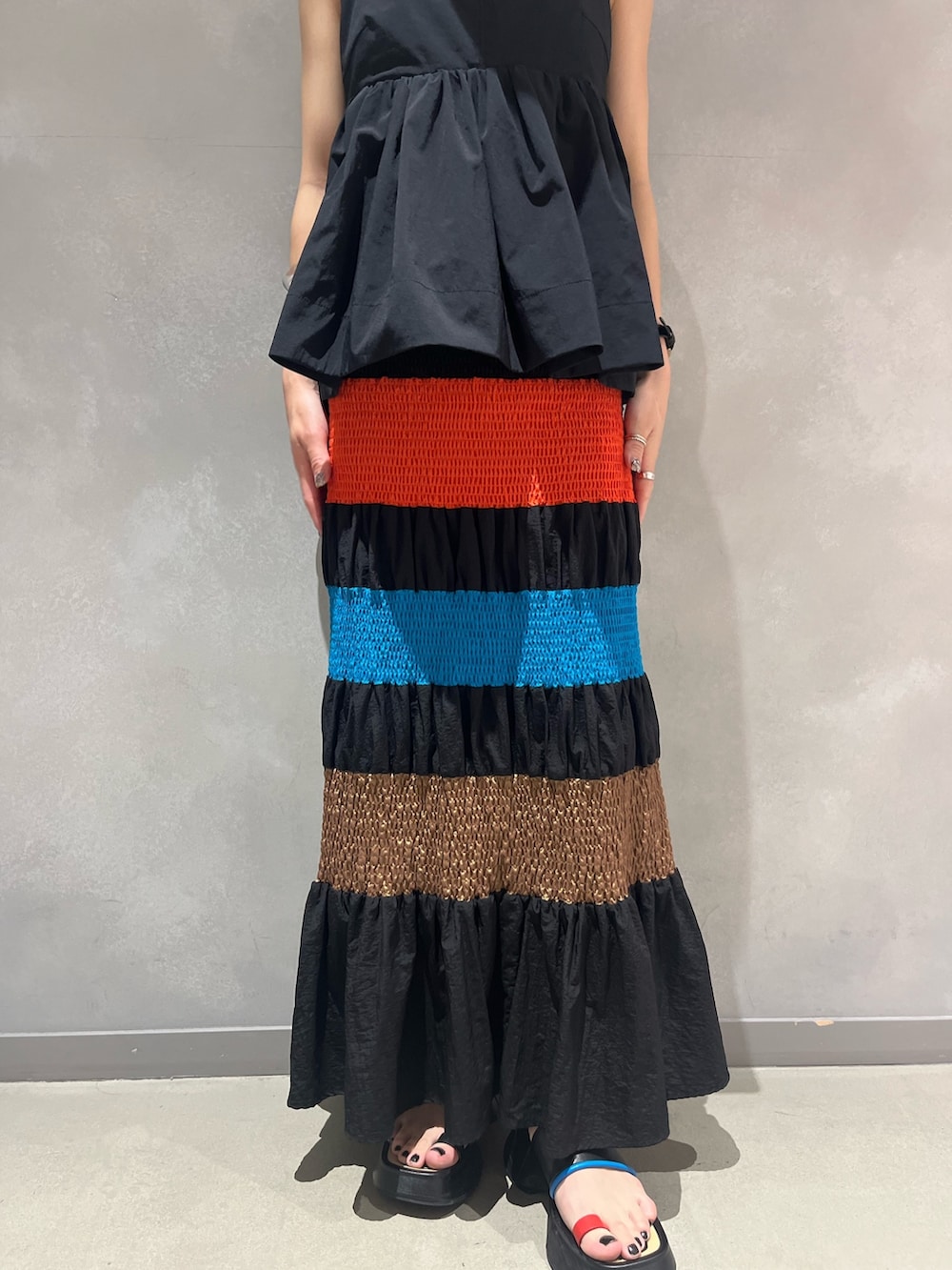 ブラック系のキャミソール、ブラック系のタンクトップ、ブラック系のスカートを着用したレディースの夏コーディネートの5枚目の写真