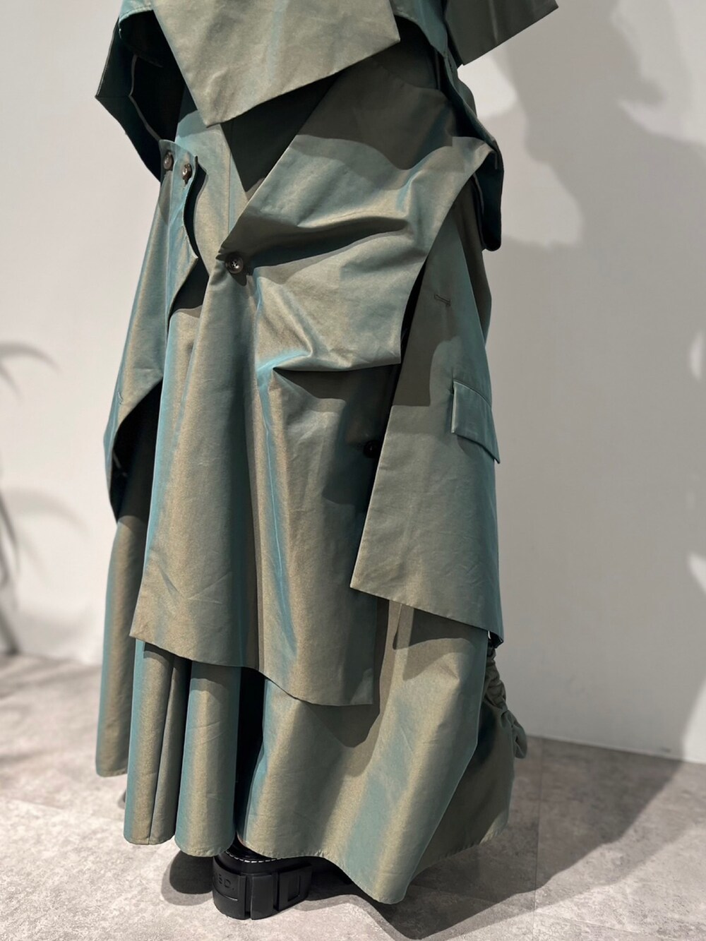 グリーン系のスカート、ベージュ系のキャミソール、ブラック系のサンダルを着用したレディースの冬コーディネートの10枚目の写真