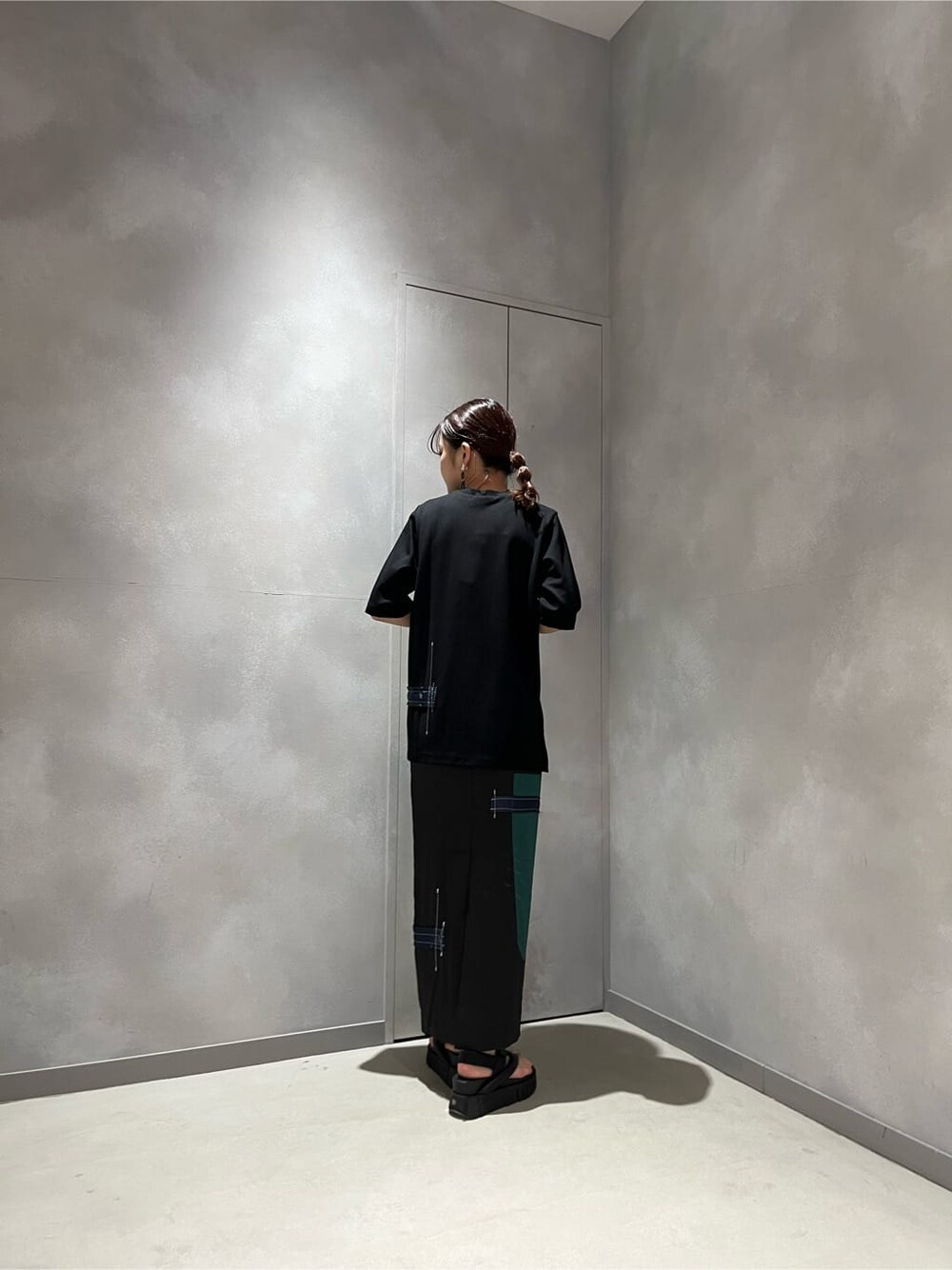 ブラック系のTシャツ/カットソー、ブラック系のスカート、ブラック系のサンダルを着用したレディースの春コーディネートの3枚目の写真