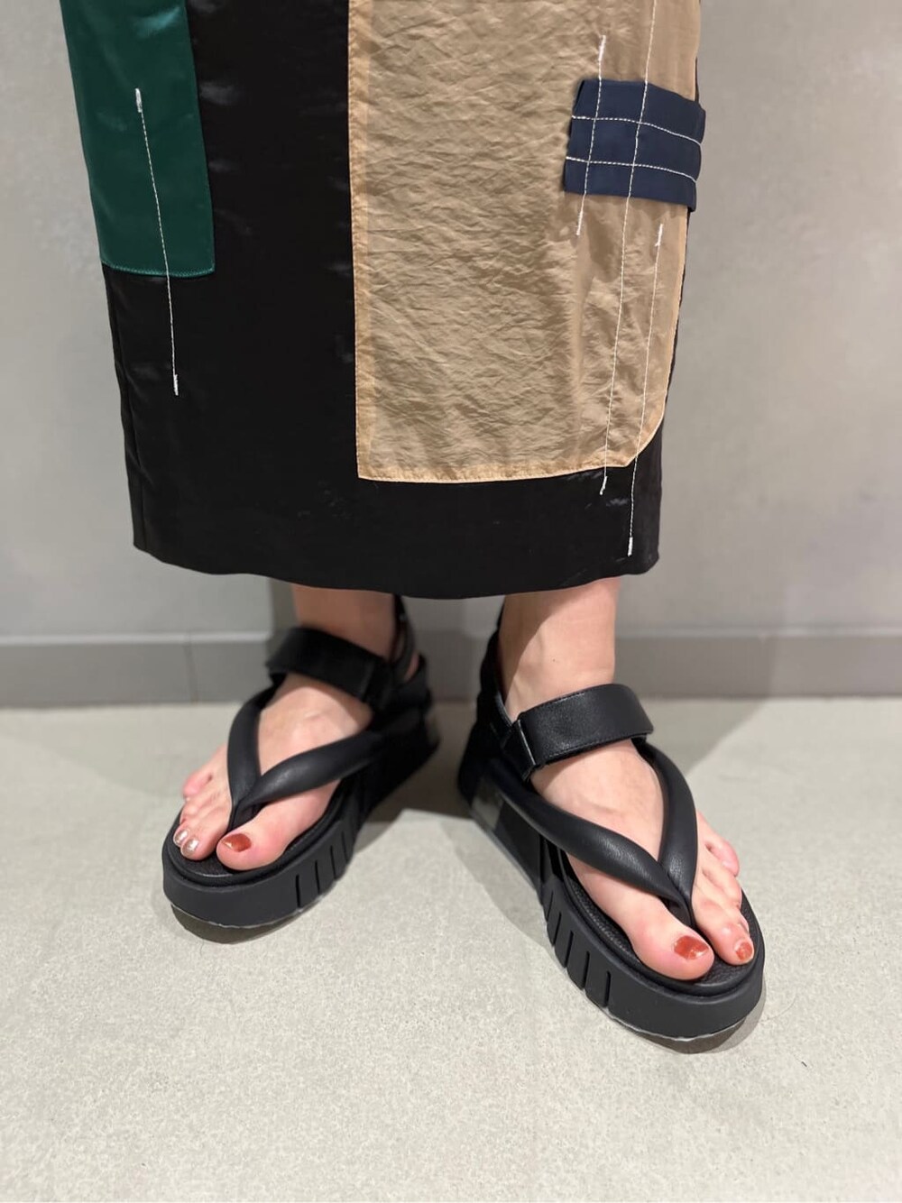 ブラック系のTシャツ/カットソー、ブラック系のスカート、ブラック系のサンダルを着用したレディースの春コーディネートの9枚目の写真