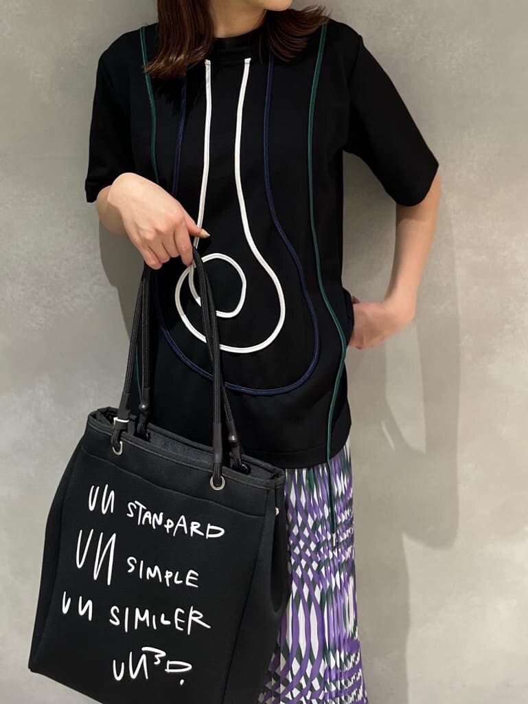 パープル系のスカート、ブラック系のTシャツ/カットソー、ブラック系のサンダルを着用したレディースの夏コーディネートの4枚目の写真