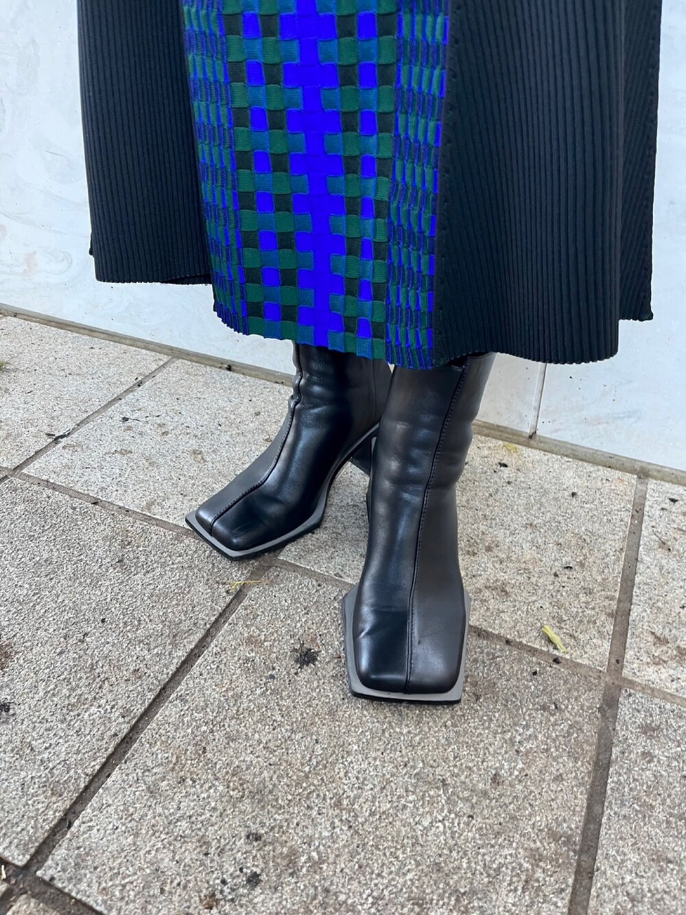 ホワイト系のタンクトップ、ブラック系のニット/セーター、ブラック系のスカートを着用したレディースの春コーディネートの8枚目の写真