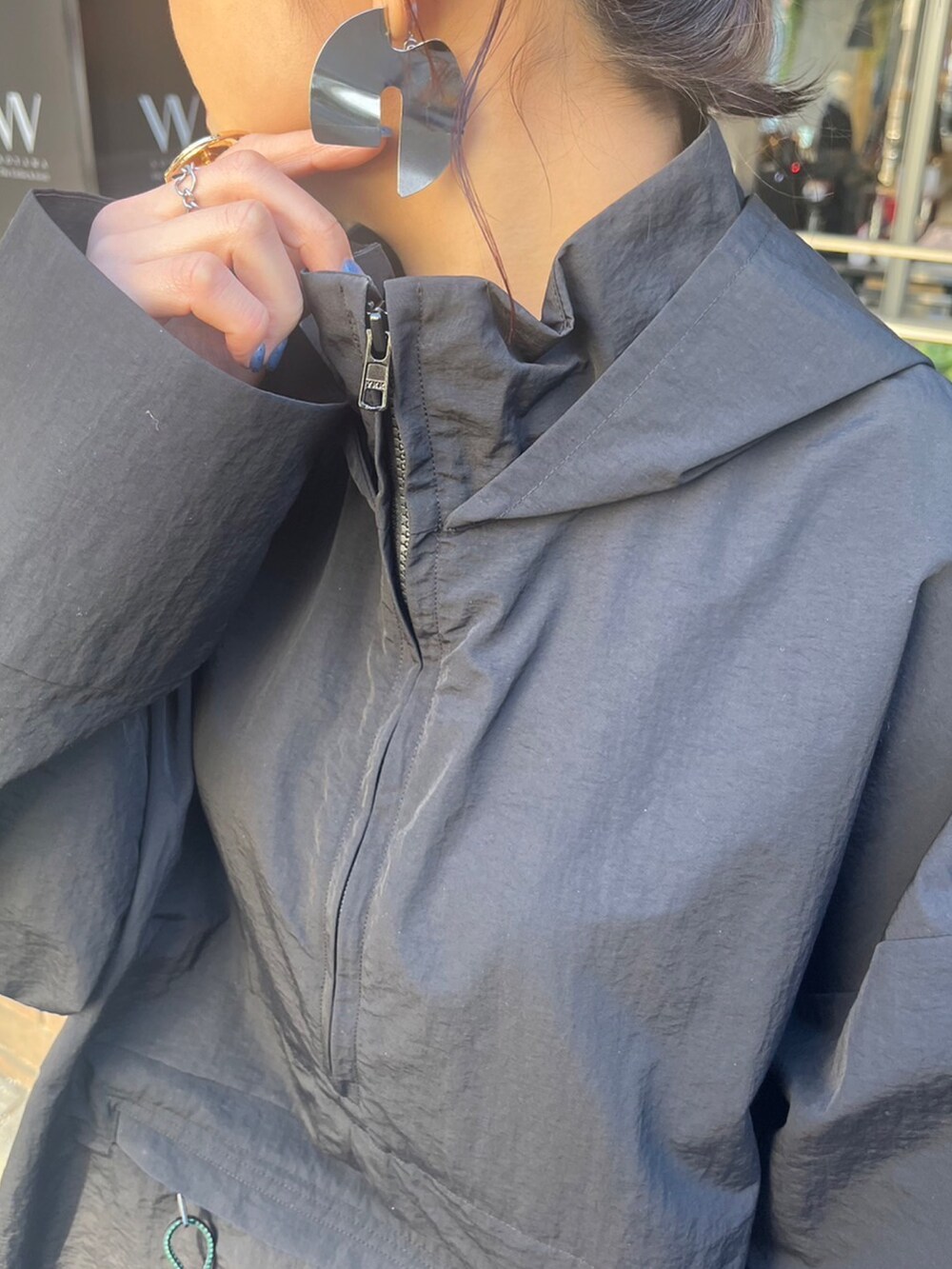 ブラック系のマウンテンパーカー、ブラック系のスカート、シルバー系のブーツを着用したレディースの冬コーディネートの5枚目の写真