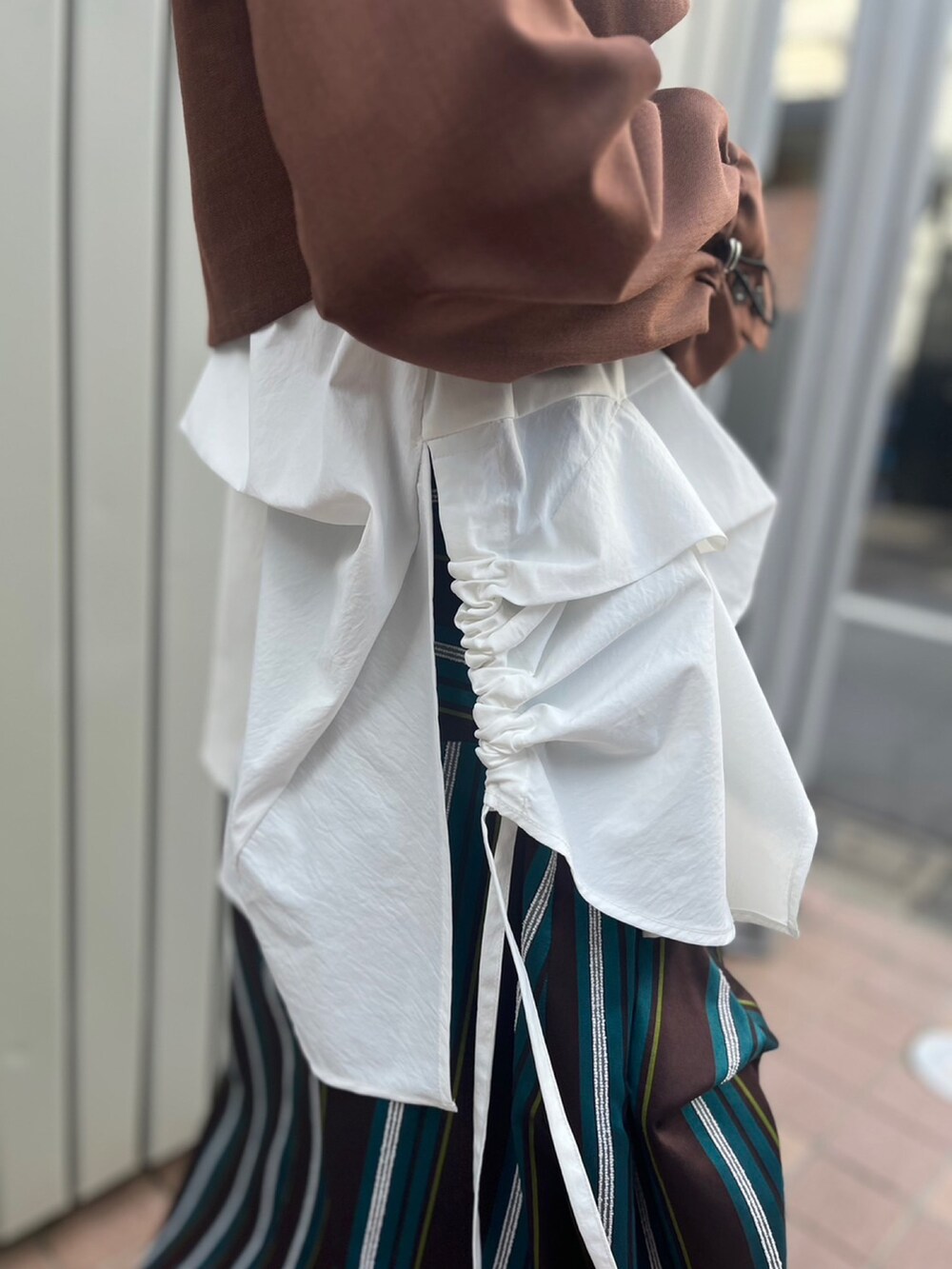 ブラウン系のノーカラージャケット、ホワイト系のTシャツ/カットソー、ブラウン系のスカートを着用したレディースの夏コーディネートの7枚目の写真
