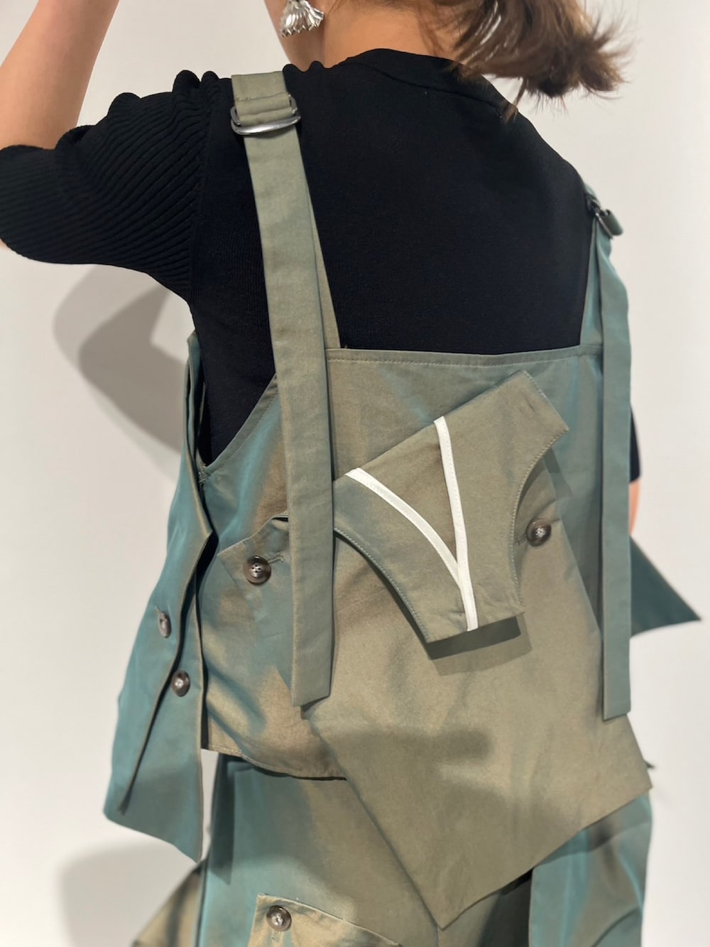 グリーン系のスカート、ベージュ系のキャミソール、ブラック系のサンダルを着用したレディースの冬コーディネートの7枚目の写真