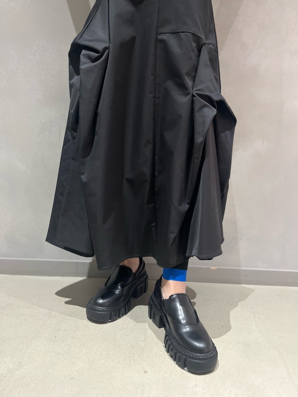 ベージュ系のベスト、ブラック系のTシャツ/カットソー、ブラック系のスカートを着用したレディースの秋コーディネートの10枚目の写真