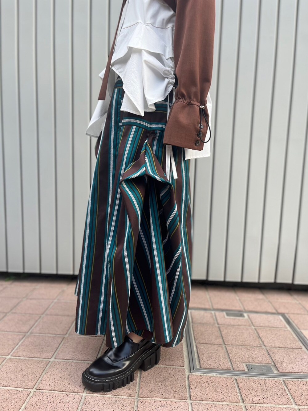ブラウン系のノーカラージャケット、ホワイト系のTシャツ/カットソー、ブラウン系のスカートを着用したレディースの夏コーディネートの9枚目の写真