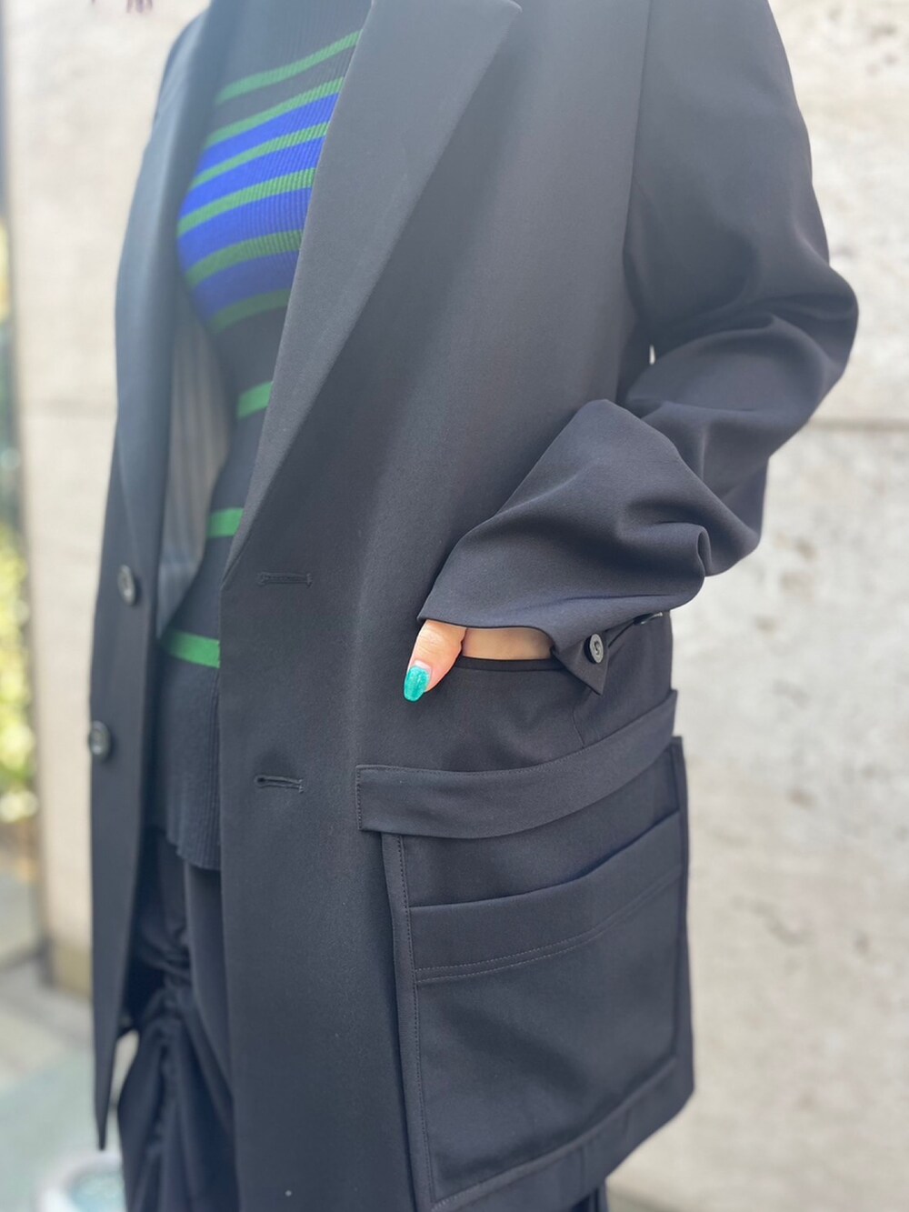 ブラック系のスカート、ブラック系のパンプス、ブラック系のテーラードジャケットを着用したレディースの冬コーディネートの8枚目の写真