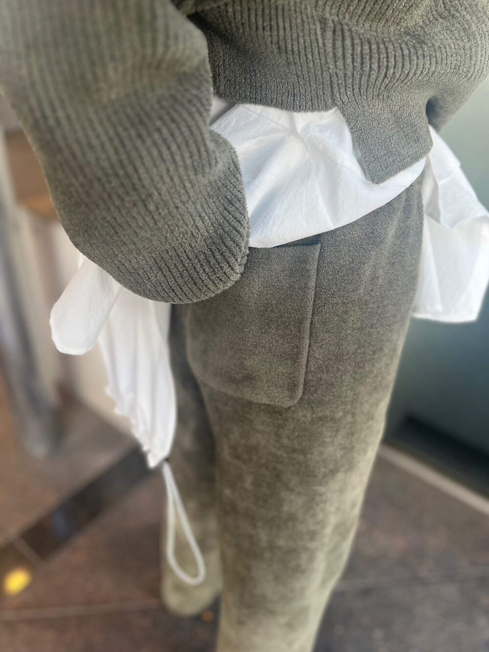 グリーン系のニット/セーター、グリーン系のその他パンツ、ホワイト系のシャツ/ブラウスを着用したレディースの秋コーディネートの8枚目の写真