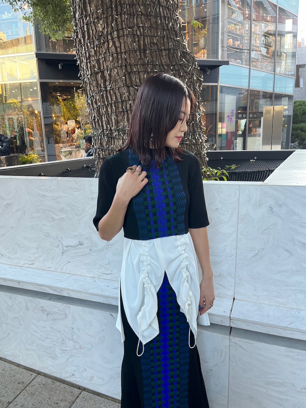 ホワイト系のタンクトップ、ブラック系のニット/セーター、ブラック系のスカートを着用したレディースの春コーディネートの3枚目の写真