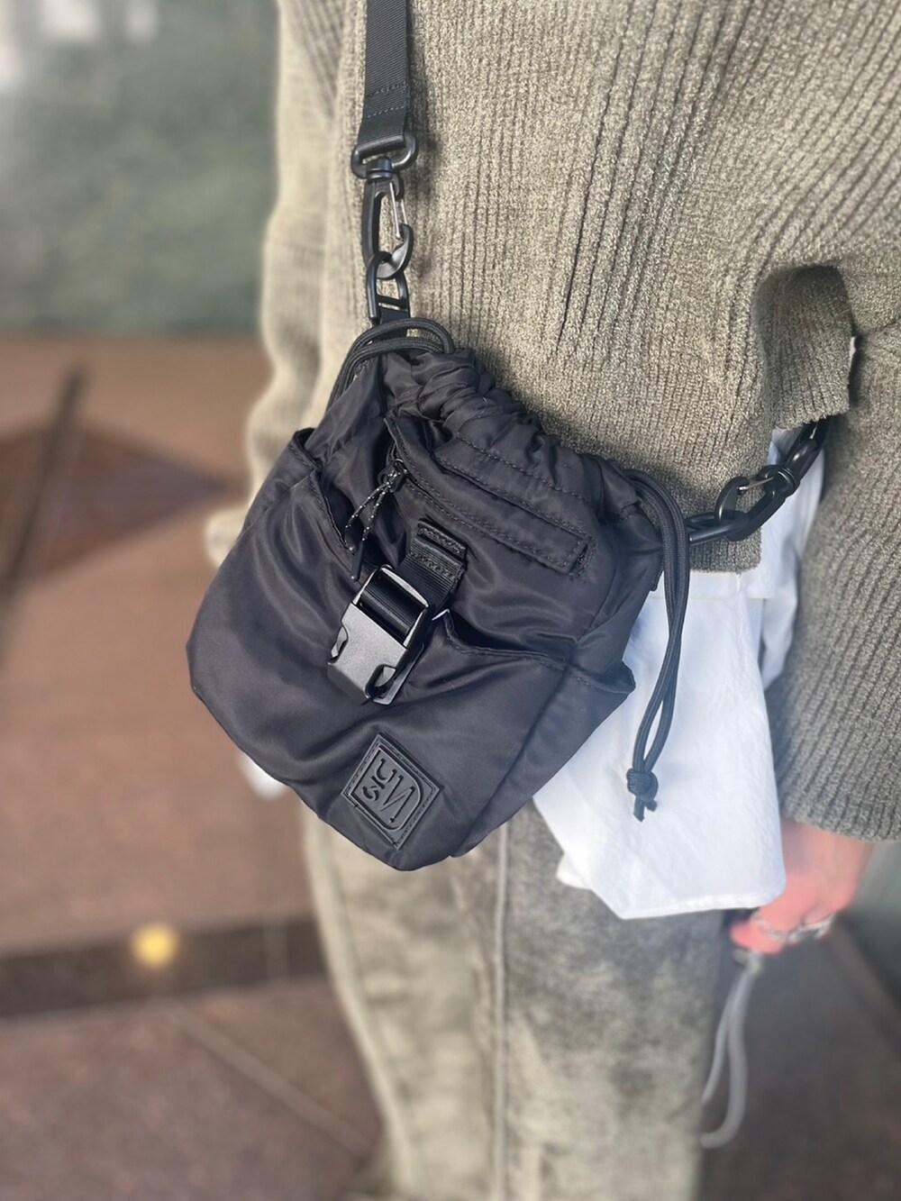 グリーン系のニット/セーター、グリーン系のその他パンツ、ホワイト系のシャツ/ブラウスを着用したレディースの秋コーディネートの9枚目の写真