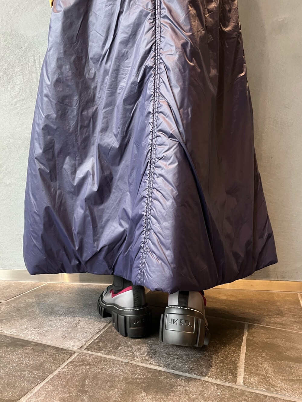 グレー系のブーツ、ブルー系のワンピース、シルバー系のネックレスを着用したレディースの秋コーディネートの10枚目の写真