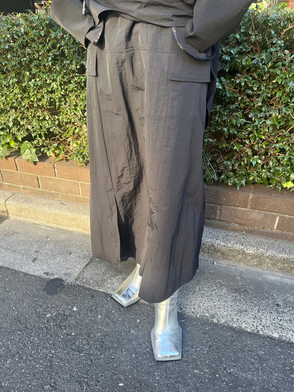 ブラック系のマウンテンパーカー、ブラック系のスカート、シルバー系のブーツを着用したレディースの冬コーディネートの9枚目の写真