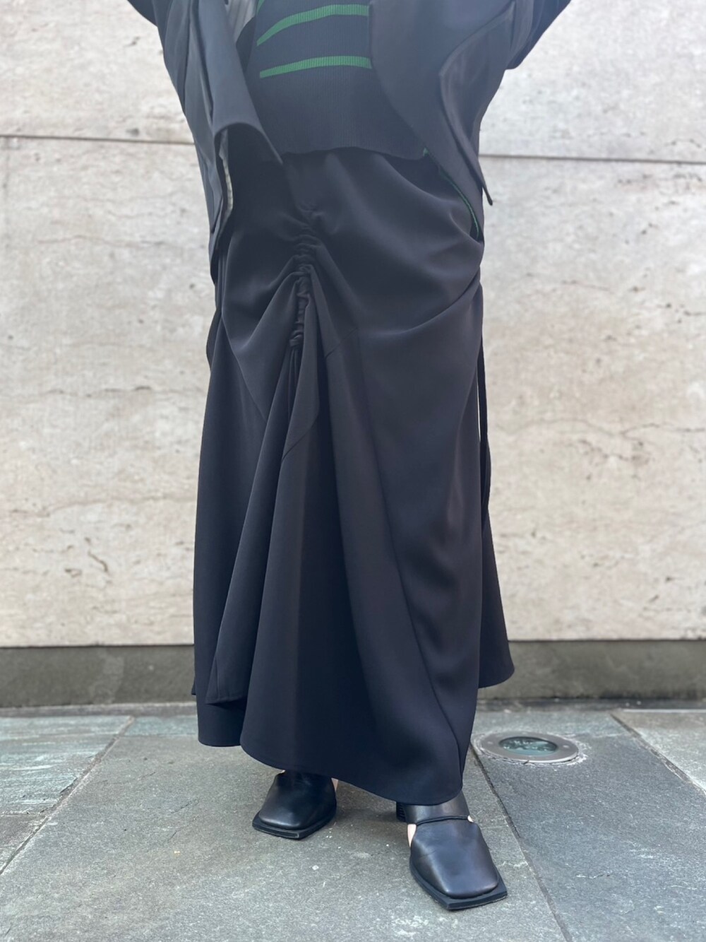 ブラック系のスカート、ブラック系のパンプス、ブラック系のテーラードジャケットを着用したレディースの冬コーディネートの10枚目の写真