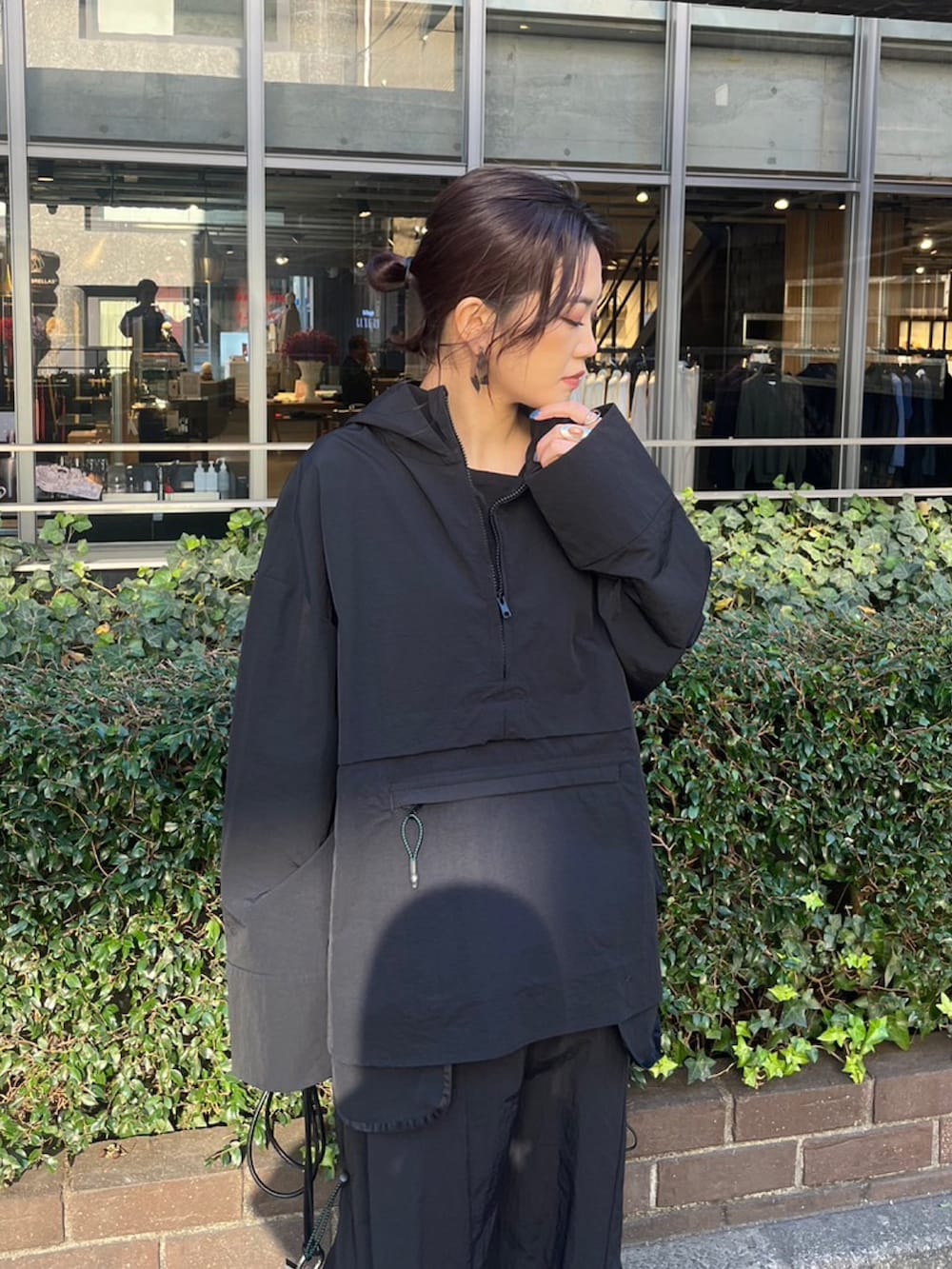 ブラック系のマウンテンパーカー、ブラック系のスカート、シルバー系のブーツを着用したレディースの冬コーディネートの4枚目の写真