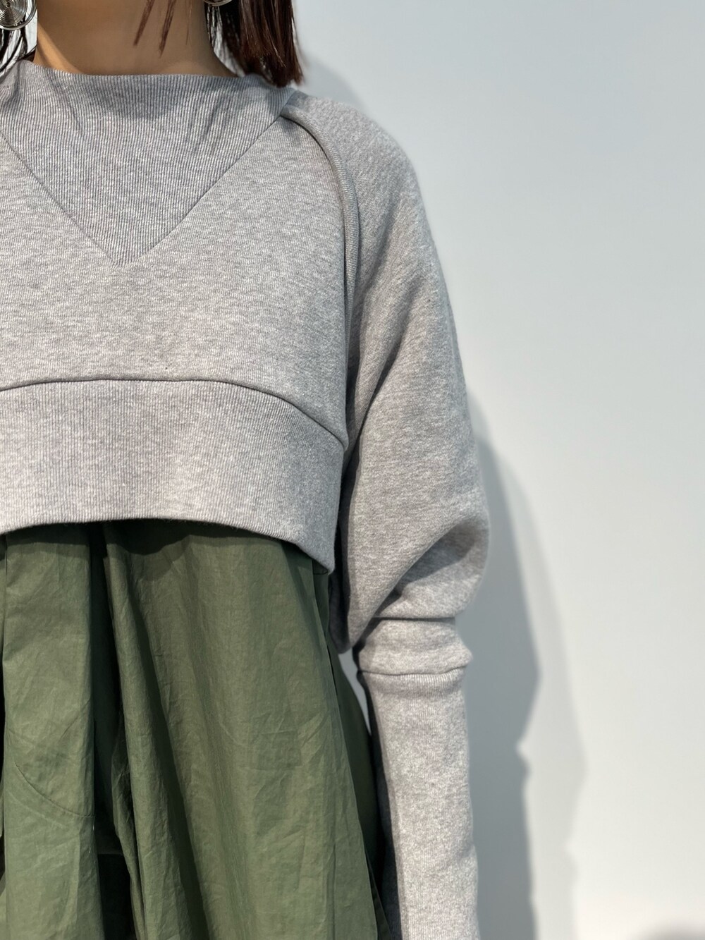 ブラック系のスカート、グリーン系のキャミソール、ブラック系のパンプスを着用したレディースの冬コーディネートの5枚目の写真