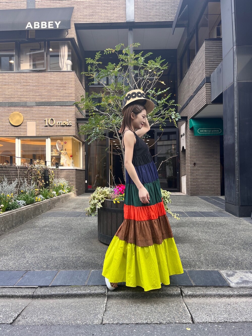 ホワイト系のサンダル、イエロー系のワンピース、ベージュ系のハットを着用したレディースの冬コーディネートの2枚目の写真