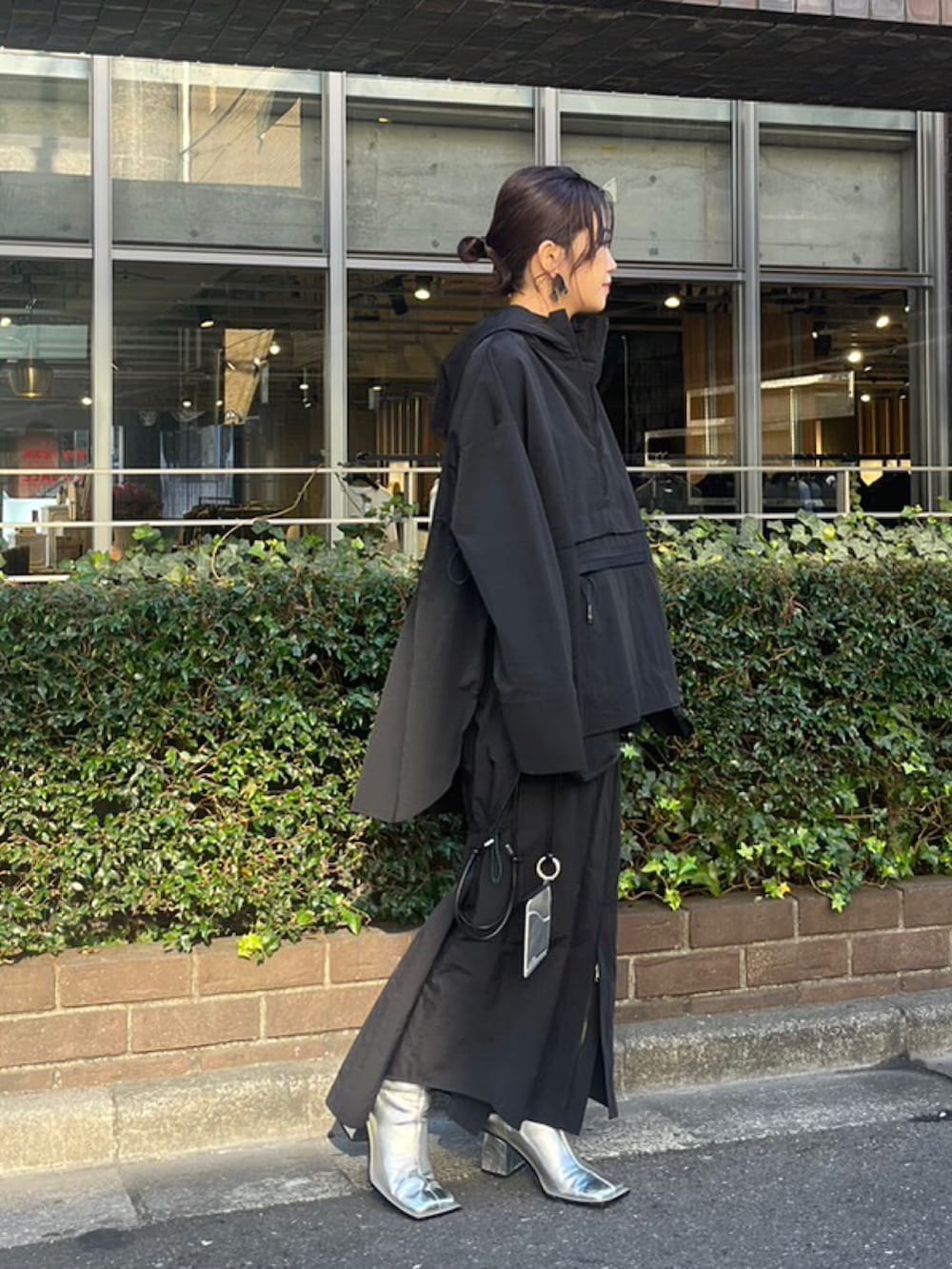 ブラック系のマウンテンパーカー、ブラック系のスカート、シルバー系のブーツを着用したレディースの冬コーディネートの2枚目の写真