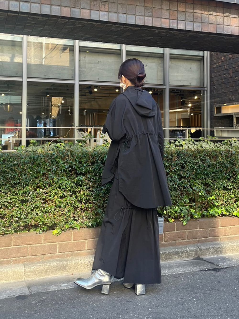 ブラック系のマウンテンパーカー、ブラック系のスカート、シルバー系のブーツを着用したレディースの冬コーディネートの3枚目の写真