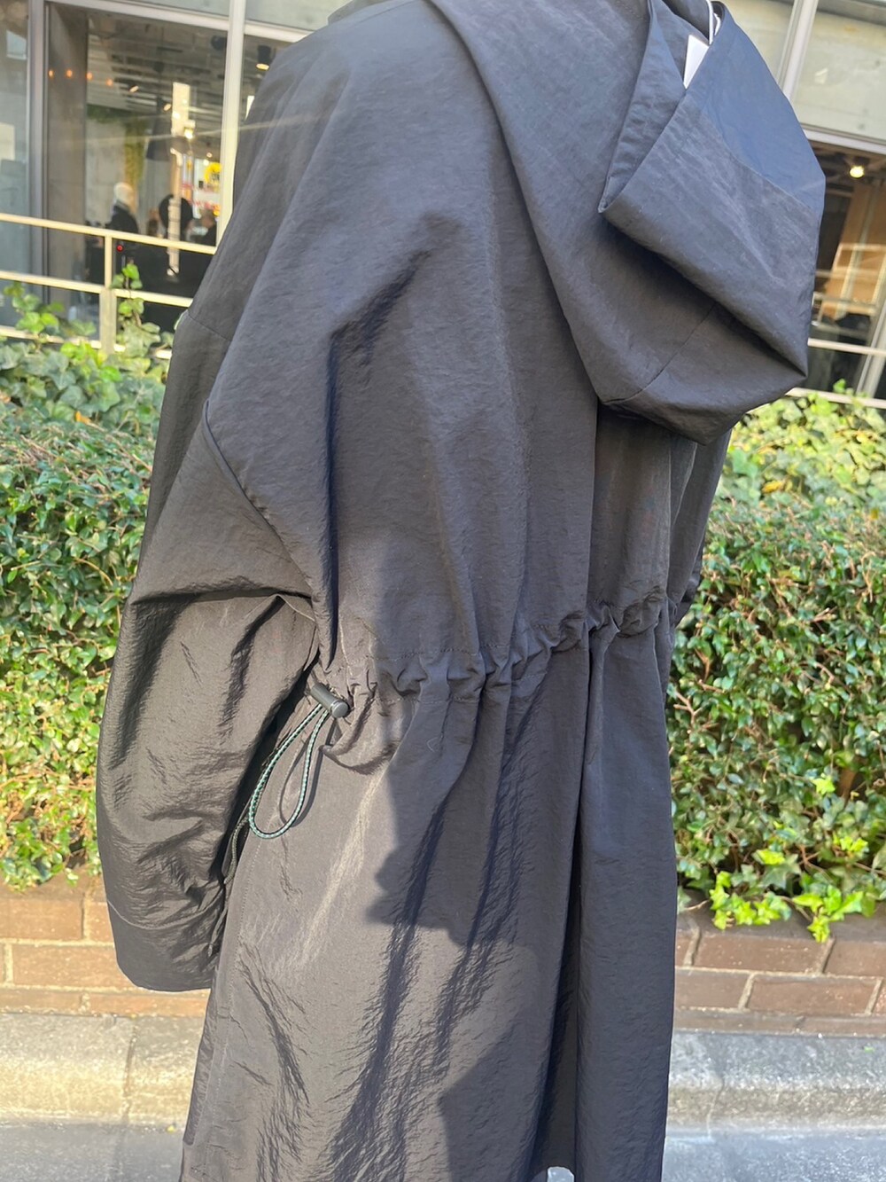 ブラック系のマウンテンパーカー、ブラック系のスカート、シルバー系のブーツを着用したレディースの冬コーディネートの8枚目の写真