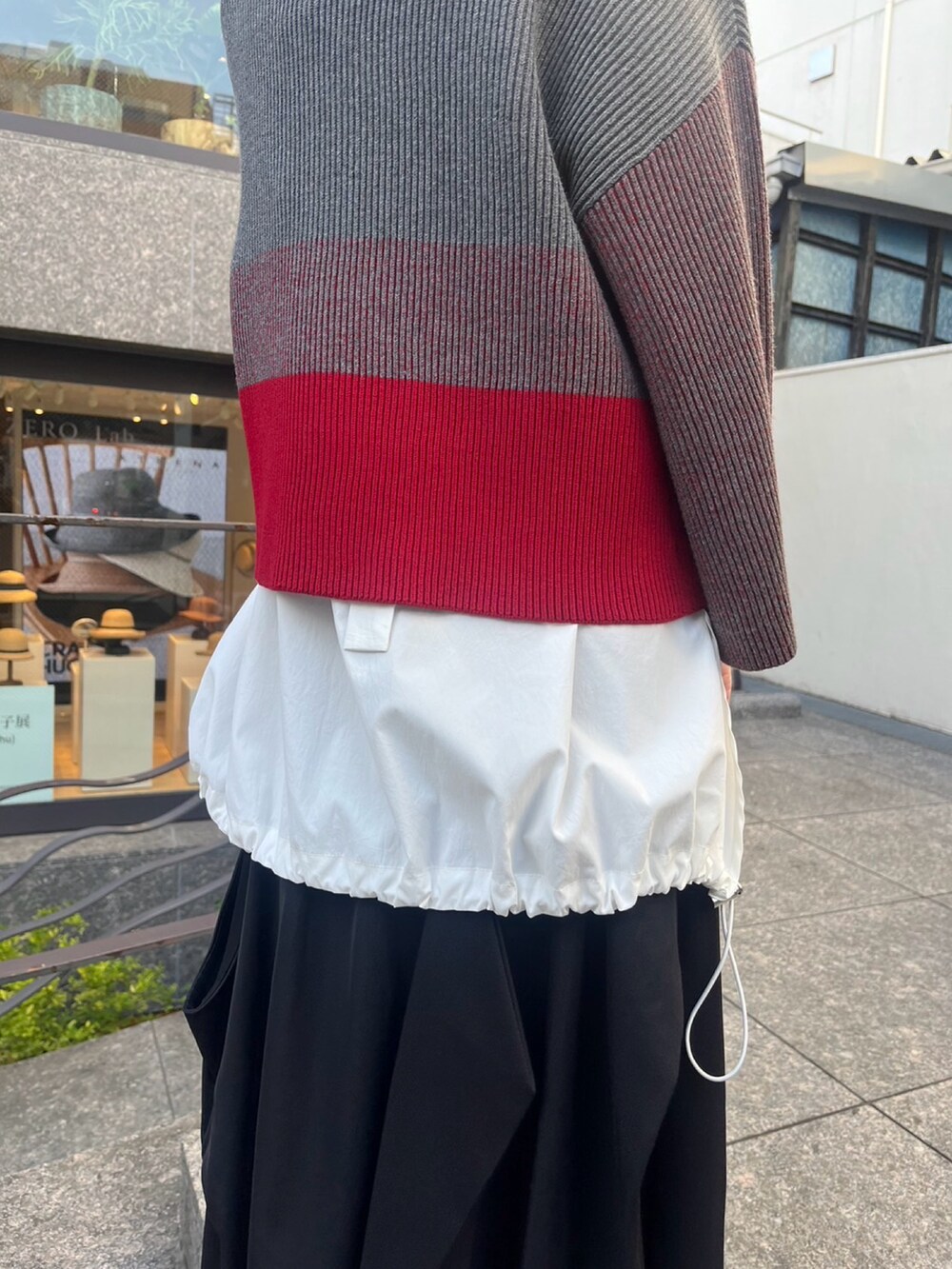 グレー系のニット/セーター、ホワイト系のシャツ/ブラウス、シルバー系のパンプスを着用したレディースの夏コーディネートの8枚目の写真