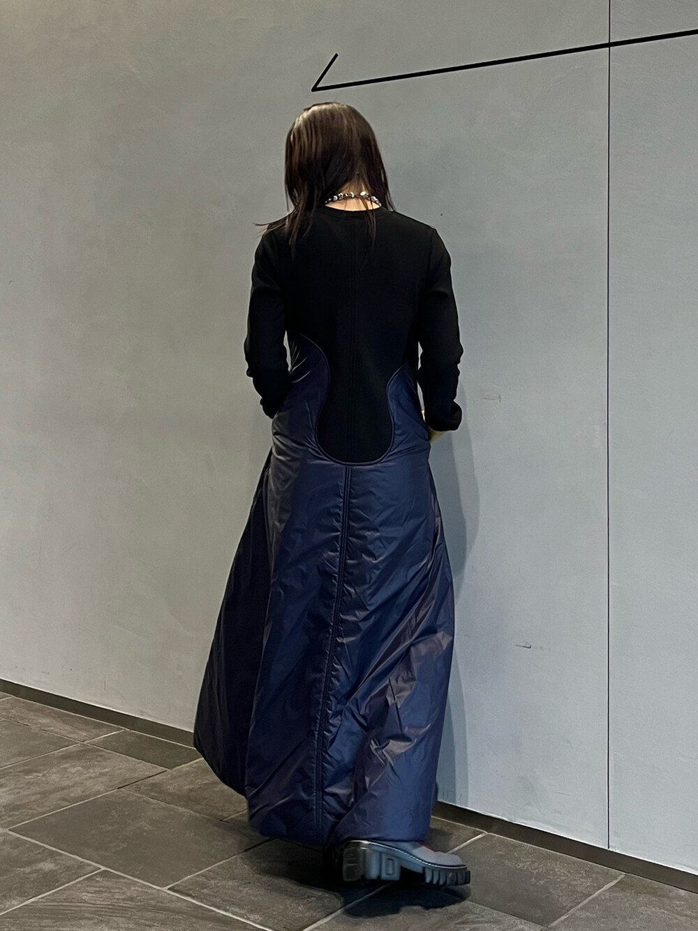 グレー系のブーツ、ブルー系のワンピース、シルバー系のネックレスを着用したレディースの秋コーディネートの3枚目の写真