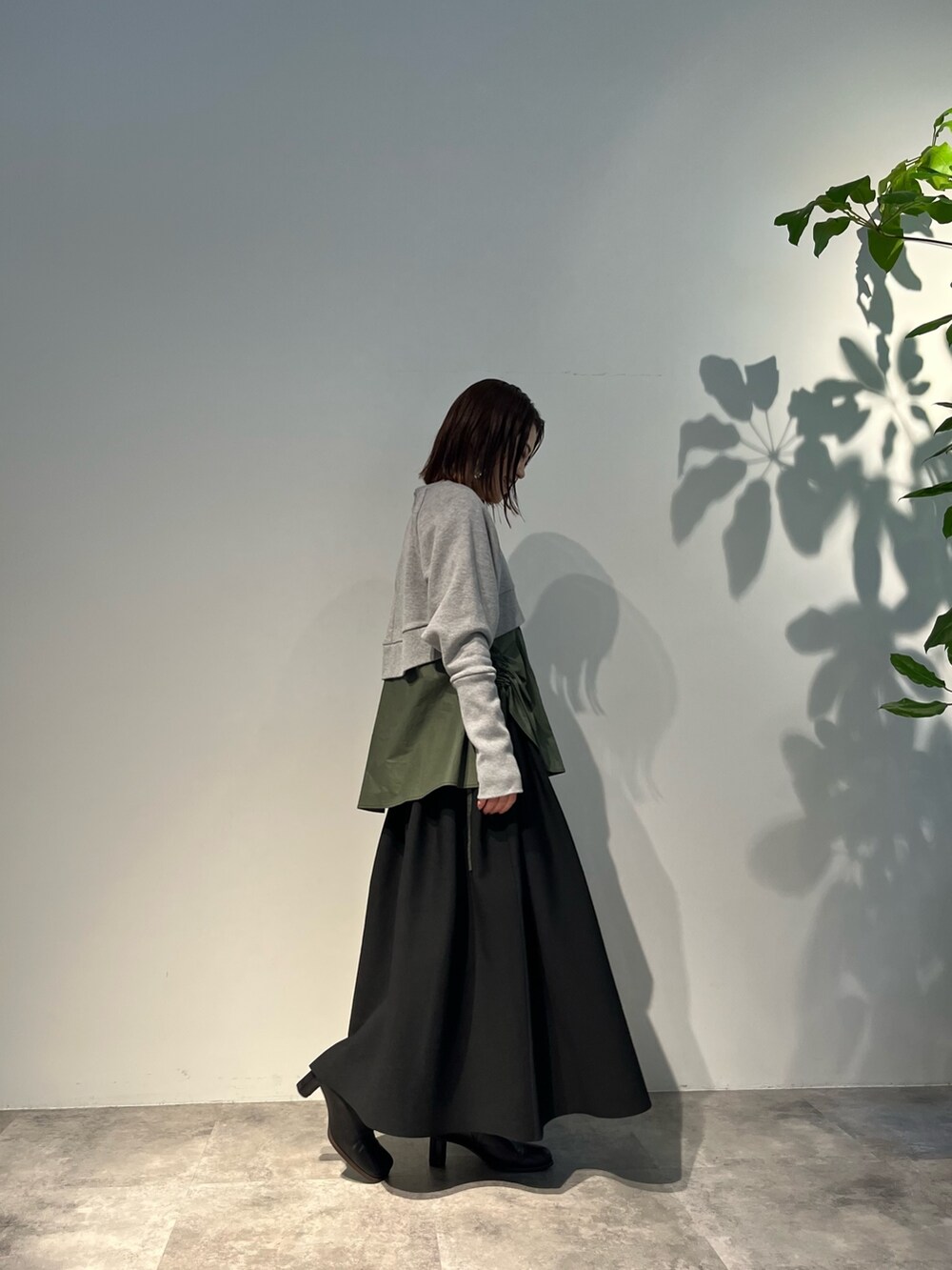 ブラック系のスカート、グリーン系のキャミソール、ブラック系のパンプスを着用したレディースの冬コーディネートの3枚目の写真