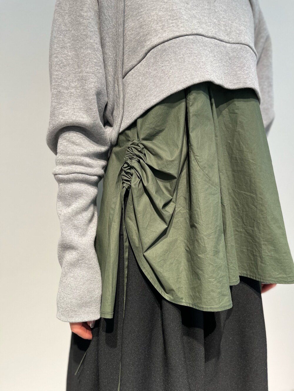 ブラック系のスカート、グリーン系のキャミソール、ブラック系のパンプスを着用したレディースの冬コーディネートの6枚目の写真