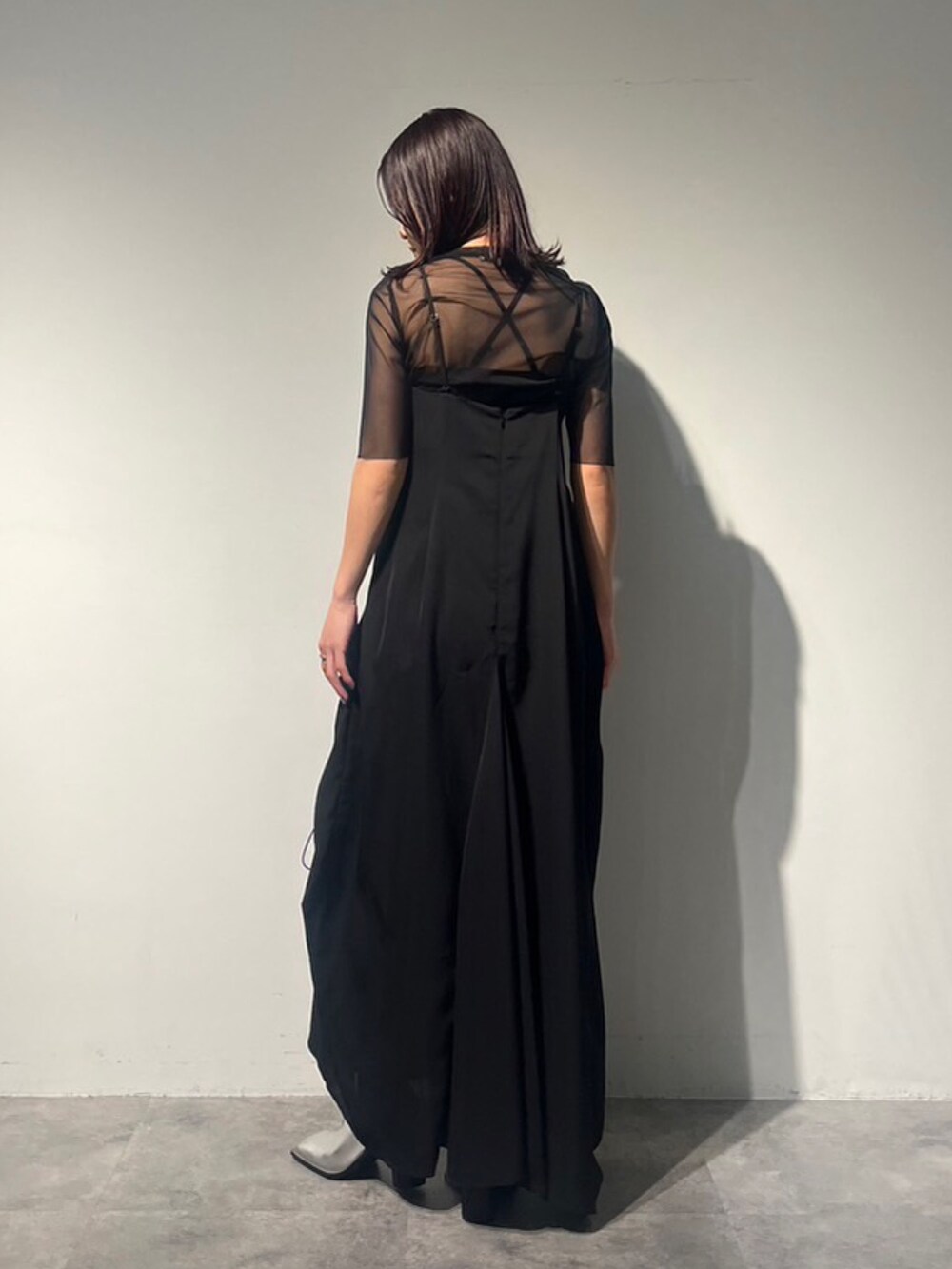 ブラック系のワンピース、ブラック系のTシャツ/カットソー、シルバー系のパンプスを着用したレディースの夏コーディネートの2枚目の写真