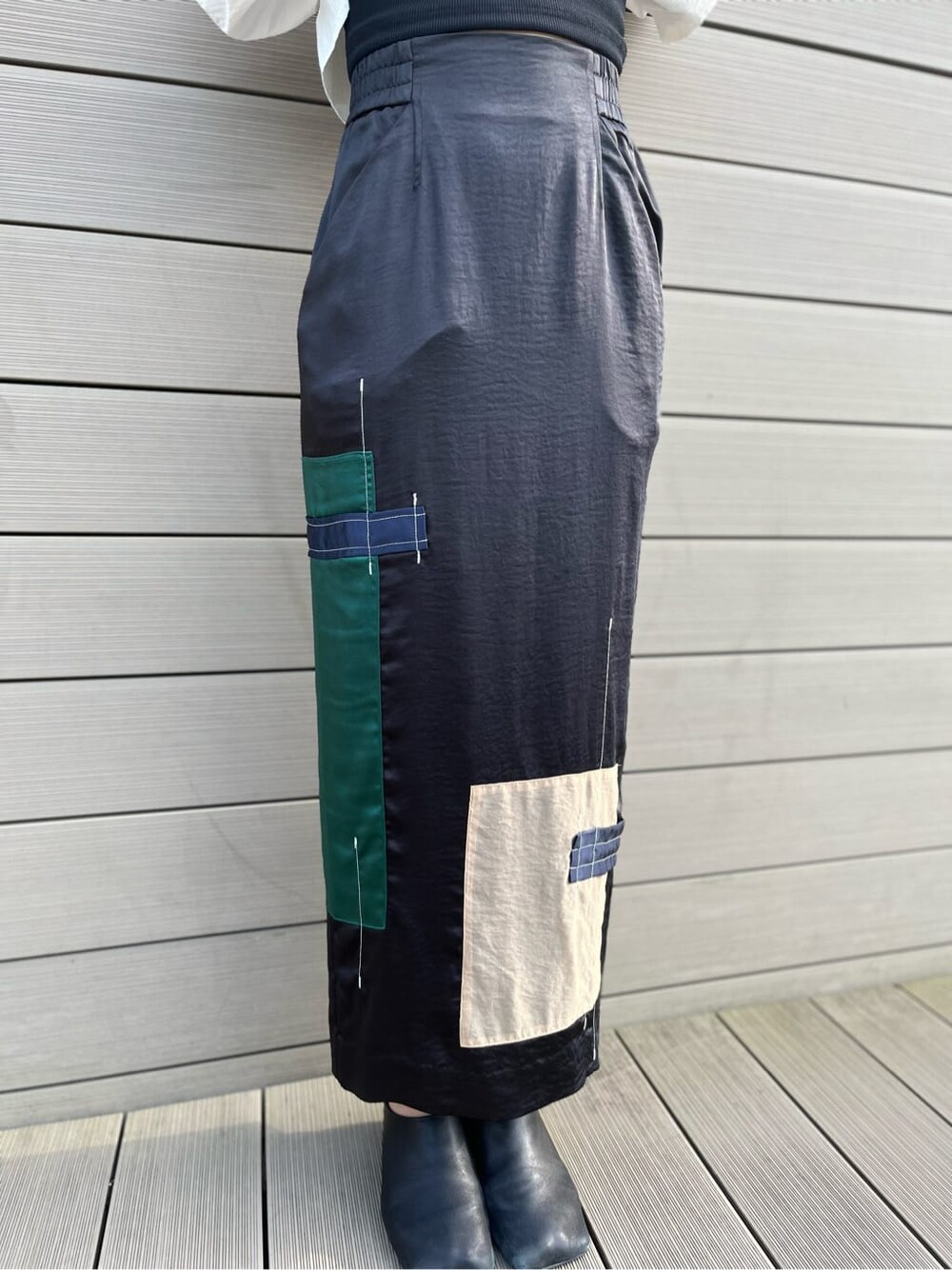 ブラック系のTシャツ/カットソー、ブラック系のスカート、ブラック系のサンダルを着用したレディースの春コーディネートの6枚目の写真