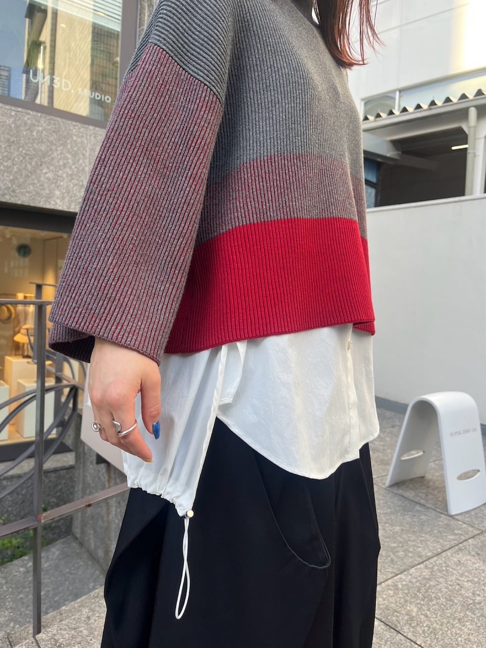 グレー系のニット/セーター、ホワイト系のシャツ/ブラウス、シルバー系のパンプスを着用したレディースの夏コーディネートの4枚目の写真