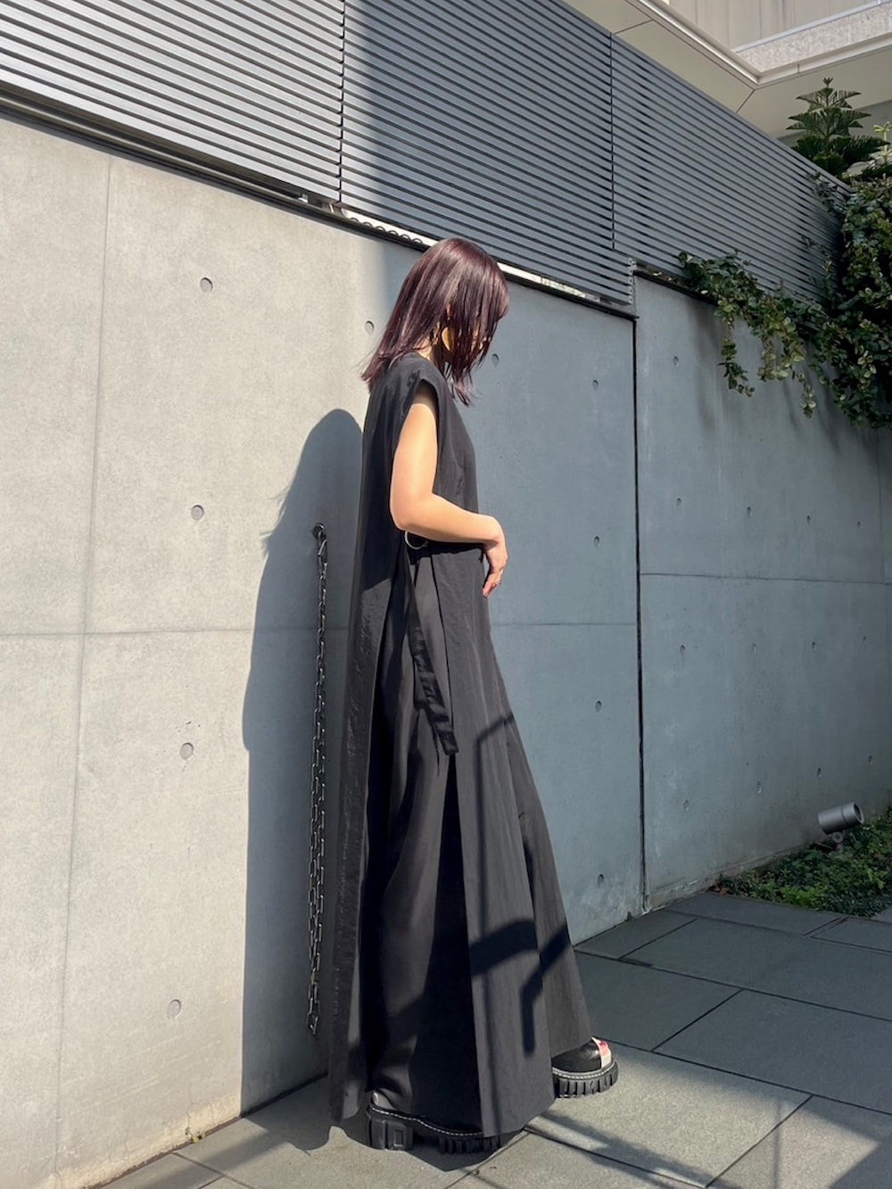 ブラック系のつなぎ/オールインワン、その他のサンダル、ゴールド系のピアス（両耳用）を着用したレディースの春コーディネートの2枚目の写真