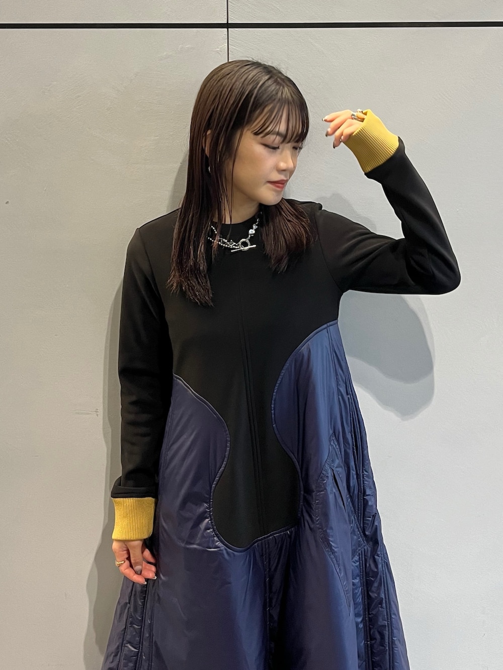 グレー系のブーツ、ブルー系のワンピース、シルバー系のネックレスを着用したレディースの秋コーディネートの4枚目の写真