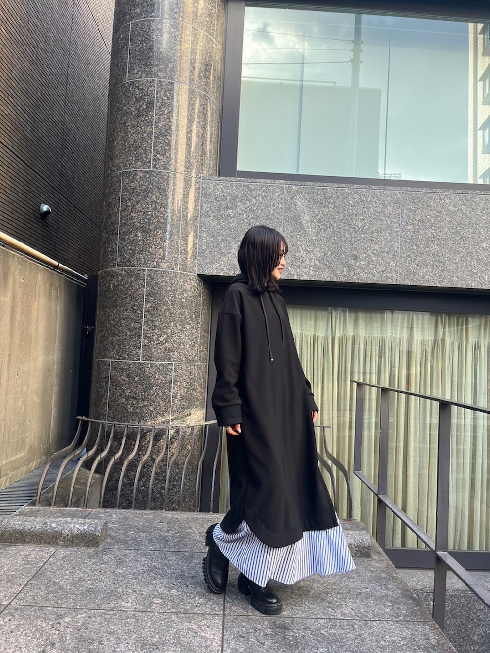 ブラック系のブーツ、ブラック系のワンピースを着用したレディースの冬コーディネートの2枚目の写真