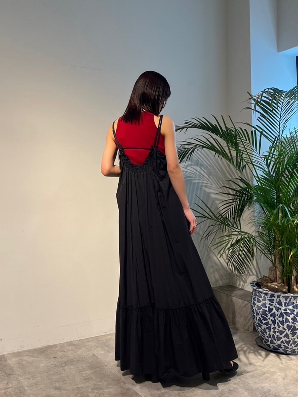 レッド系のタンクトップ、ブラック系のサンダル、ブラック系のスーツケース/キャリーバッグを着用したレディースの春コーディネートの3枚目の写真