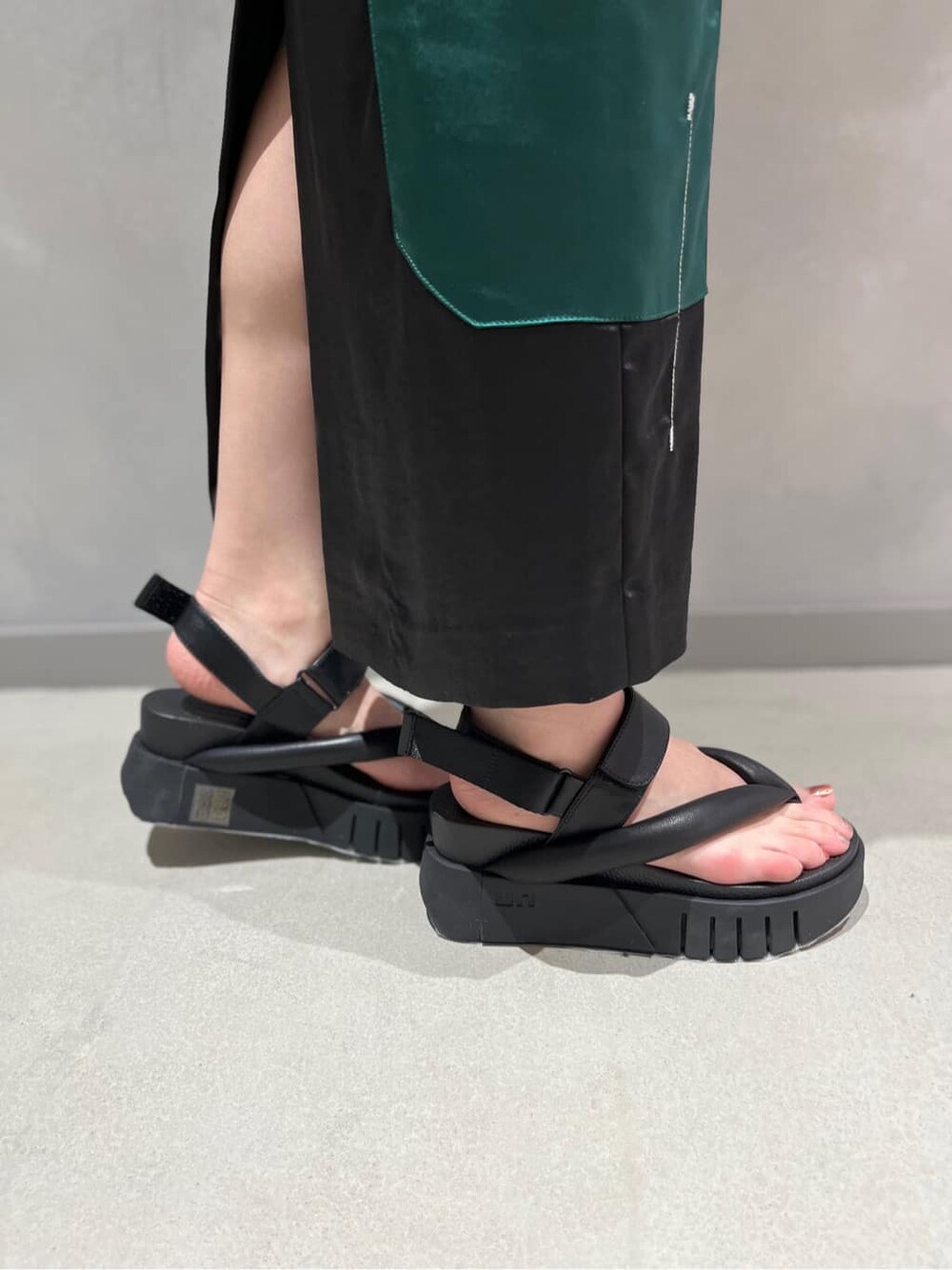 ブラック系のTシャツ/カットソー、ブラック系のスカート、ブラック系のサンダルを着用したレディースの春コーディネートの8枚目の写真