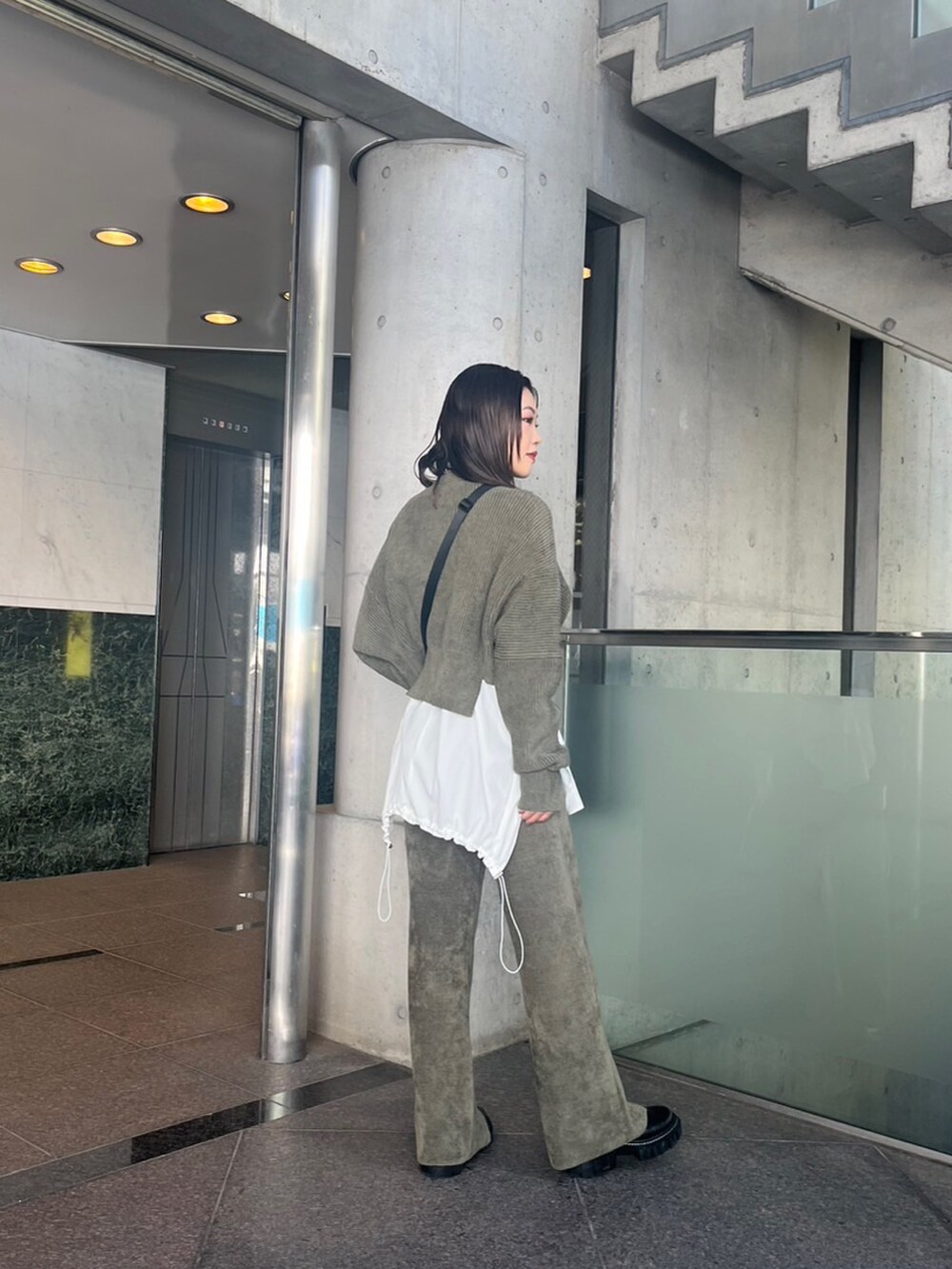 グリーン系のニット/セーター、グリーン系のその他パンツ、ホワイト系のシャツ/ブラウスを着用したレディースの秋コーディネートの2枚目の写真