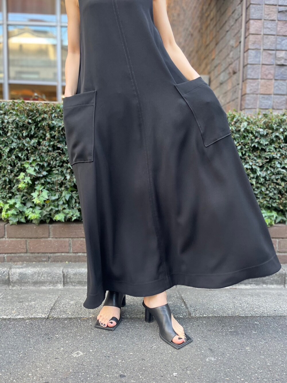 ブラック系のワンピース、ブラック系のサンダル、ブラック系のハットを着用したレディースの春コーディネートの5枚目の写真