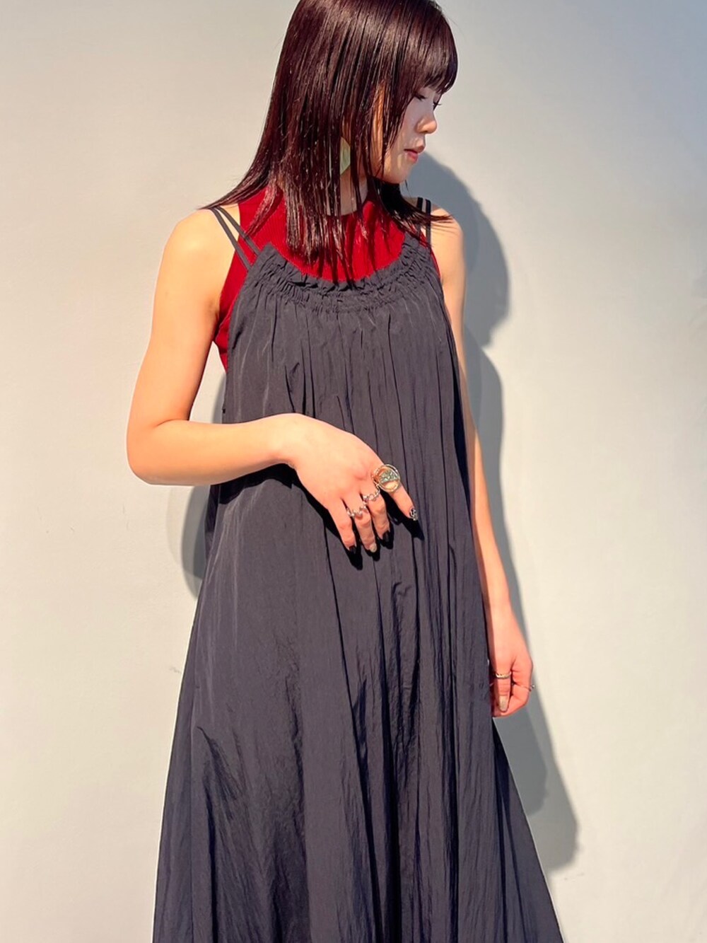 レッド系のタンクトップ、ブラック系のサンダル、ブラック系のスーツケース/キャリーバッグを着用したレディースの春コーディネートの4枚目の写真