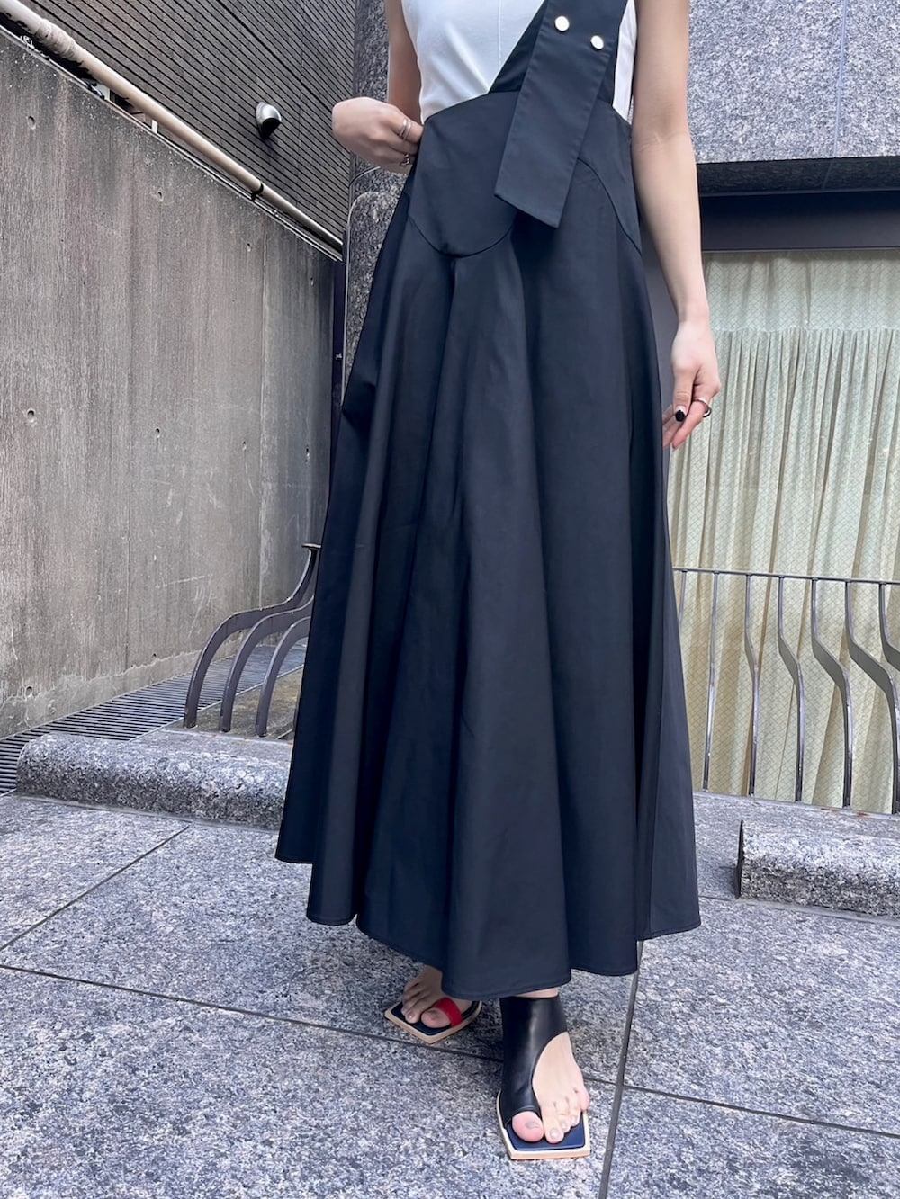 ホワイト系のタンクトップ、ブラック系のスカート、その他のサンダルを着用したレディースの春コーディネートの6枚目の写真