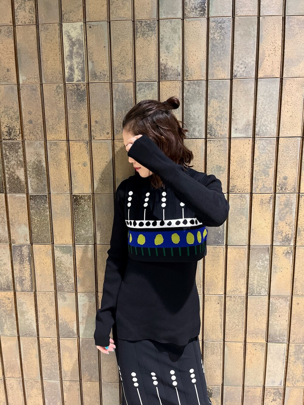 ブラック系のスカート、グレー系のノーカラーコート、ブラック系のブーツを着用したレディースの秋コーディネートの6枚目の写真