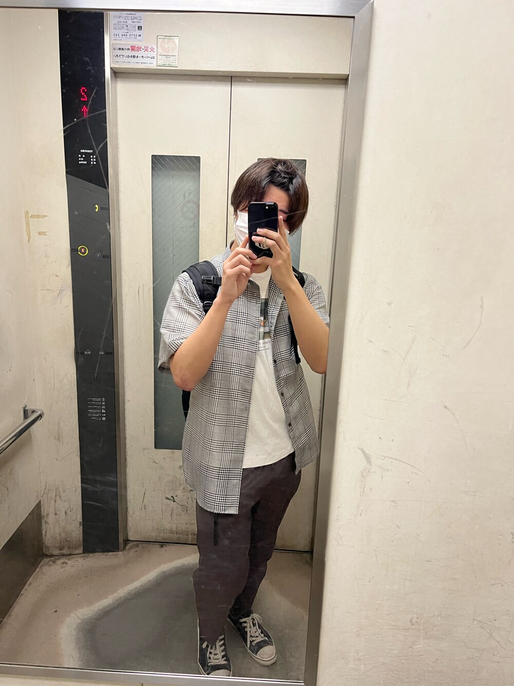 ブラウン系のスラックス、グレー系のシャツ/ブラウス、ホワイト系のTシャツ/カットソーを着用したメンズの夏コーディネートの2枚目の写真