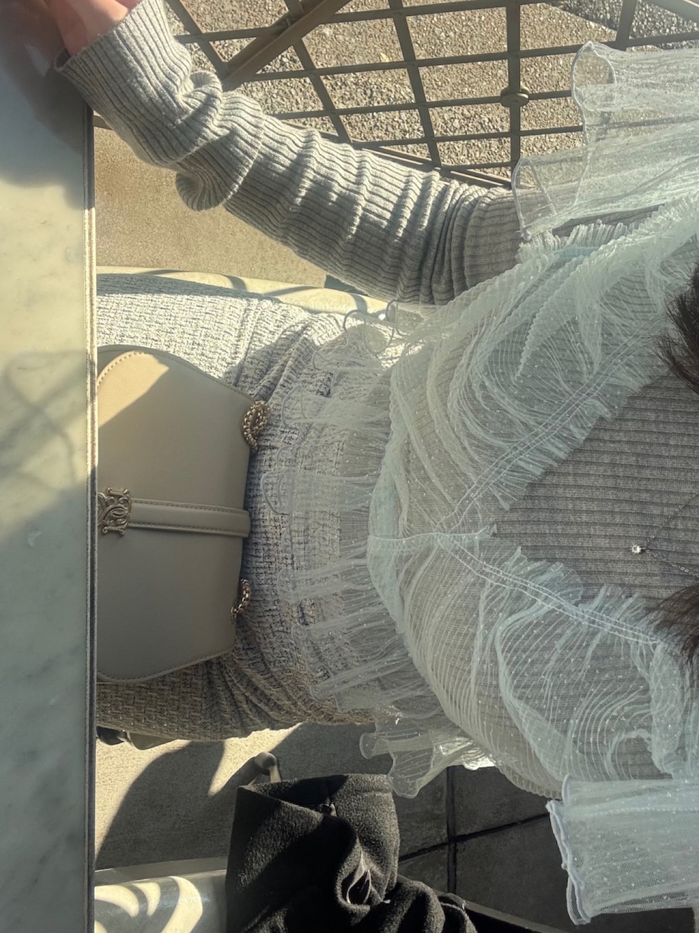 グレー系のニット/セーター、ベージュ系のショルダーバッグ、その他のスカートを着用したレディースの冬コーディネートの2枚目の写真