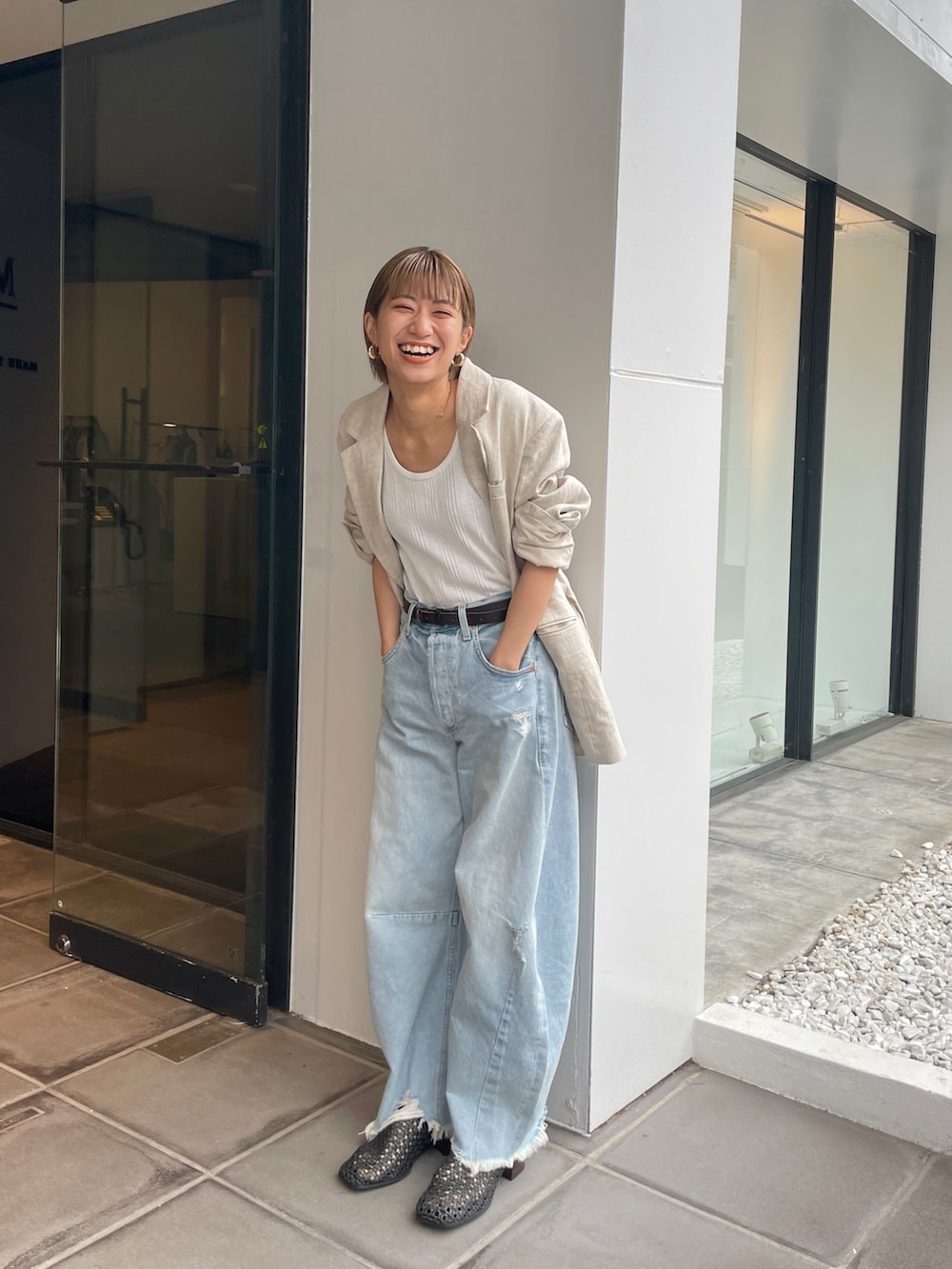 ベージュ系のテーラードジャケット、ホワイト系のタンクトップを着用したレディースの春コーディネートの10枚目の写真